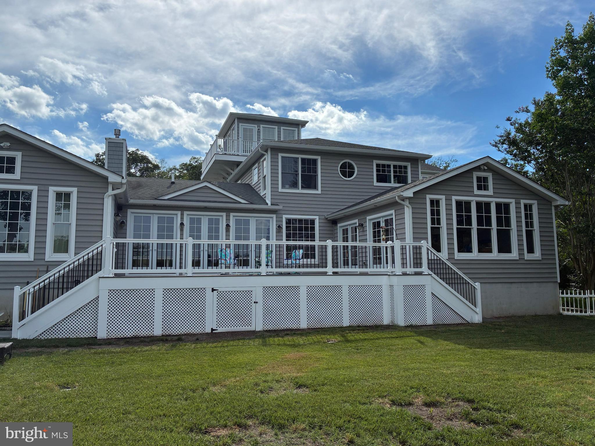 Professional Pictures are coming soon!  Nestled in the exclusive bayfront enclave of Bay Point Plantation, this beautiful coastal residence epitomizes luxury living, offering spectacular views of the Ocean City skyline. Built with intention for energy efficiency in 2011 featuring three separate Geothermal HVAC systems, this detached architectural masterpiece boasts over 4,500sqft with five spacious bedrooms and four full bathrooms with a 5th bathroom fully plumbed-in for future installation. Step inside to discover an expansive open floor plan that invites natural light to dance across the room from the floor-to-ceiling glass sliders that illuminate the natural beauty of Turville Creek with panoramic views of Ocean City's High Rise Row as its backdrop. The heart of the home is the gourmet kitchen, featuring an eat-in area perfect for casual dining, while the adjacent living spaces are enhanced by an elegant gas fireplace, creating a warm and inviting atmosphere for gatherings. Adjoining the primary living area is a 19'x19' sunroom with cathedral ceilings, built-in cabinets for entertaining, featuring its own geothermal HVAC system. The balloon framed sunroom, featuring magnificent views of Turville Creek and the OC skyline, was framed and designed ready to drop in an in-line Swim Spa with the concrete pad and electric in place. Just off the sunroom, a brand new, expansive TimberTech deck was just installed in 2026 featuring low-voltage landscape lighting which leads down to a huge flagstone patio area for additional outdoor living and entertainment space.  The Primary Suite, a true entry-level sanctuary, offers breathtaking bay views and is complemented by a Master Bathroom offering a Whirlpool Tub and ceramic tiled Rainforest ceiling shower, a spacious walk-in closet, plus an additional Half Bath with its own walk-in closet. A second entry-level bedroom with the plumbing for a future full bathroom is currently situated as an office. The stairway of the home leading to the second floor wraps around a space designed for a future elevator addition with a 6" concrete pad, electric and phone line already in place. The second floor offers an additional three bedrooms with two full baths and a large Bonus Room with its own gas fireplace, tv mount and surround sound speaker wiring. Traverse up to the cupola for a serene retreat setting, ideal for an intimate seating area to take in the spectacular, surrounding water views and the renown Golden Hour that illuminates Ocean City's skyline with rainbow hues each evening.  Every detail of this home has been meticulously designed, from the recessed lighting that highlights the home's architectural features to the exterior landscape lighting that creates ambiance for every occasion. The convenience of a main floor laundry room just off the four-car garage adds to the home's thoughtful design, while the indoor sprinkler system provides peace of mind. Enjoy the tranquility of the tidal wetland surroundings, where nature's beauty is just outside your door here on Plantation Lane. As part of a prestigious gated community, residents enjoy exclusive access to a marina club, pier, and dock, perfect for boating enthusiasts or for crabbing, fishing and sightseeing. This luxurious residence is not just a home; it's a lifestyle choice that offers the perfect blend of comfort, elegance, and natural beauty. Experience the ultimate in coastal living, where every day feels like a vacation.