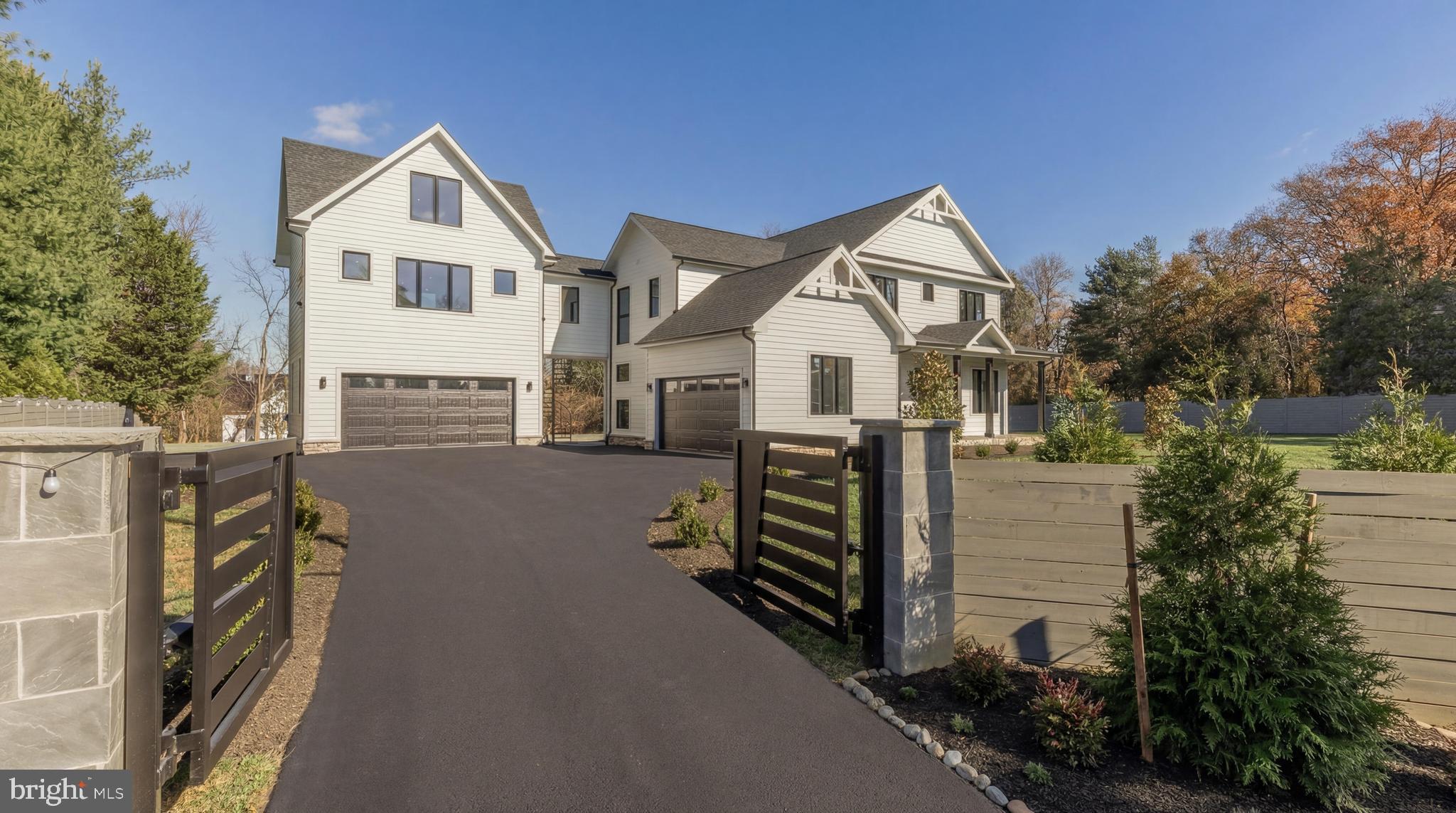 Set behind a private electric gate on a beautifully landscaped acre, Esworthy Road presents a thoughtfully designed estate that balances privacy, scale, and everyday livability. The property is composed of a three-bedroom main residence, an attached private wing that extends the home’s living space, and a detached studio, offering a rare level of flexibility to accommodate a variety of lifestyles.

A welcoming front porch introduces the main residence, where the interior opens into a light-filled main level defined by 10-foot ceilings, wide-plank hardwood flooring, and a seamless, open flow. The layout is anchored by a spacious central living area that connects effortlessly to the kitchen and dining spaces, creating an ideal environment for both daily living and entertaining.

The kitchen is designed with both function and presentation in mind, featuring an expansive center island, full-height quartz surfaces, custom cabinetry, and a complete Thermador appliance suite. It opens naturally to the surrounding living areas, allowing for easy interaction and a cohesive sense of space.

Upstairs, the primary suite offers a quiet retreat with a tray ceiling, two walk-in closets, and a well-appointed bath complete with dual vanities, a walk-in shower, private water closet, and a freestanding soaking tub. Two additional bedrooms each feature en-suite baths and walk-in closets, providing comfort and privacy for family or guests.

The fully finished lower level expands the home’s versatility, offering a large recreation area with a modern fireplace, a dedicated fitness space, an additional bedroom, and a full bath.

The attached private wing is seamlessly integrated into the main residence, designed as a natural extension of the home while offering flexibility for more private living. Equipped with its own HVAC system, water heater, and laundry connections, the space allows for independence without sacrificing cohesion. With the ability to accommodate a full kitchen, bedroom, full bath, and open living area, it functions effortlessly as an additional living suite, ideal for multigenerational living, long-term guests, or a refined work-from-home environment, all within the footprint of the main home.

A separate detached studio provides additional flexibility, ideal for creative use, a gym, or a quiet workspace.

Outdoor living is just as compelling, with a semicircular bluestone patio extending from the home into the surrounding landscape, creating a natural setting for dining and entertaining. The yard is level, expansive, and fully fenced, offering both privacy and usability.

Additional features include a four-car garage with EV charging, a high-efficiency septic system, and a private well.

With its combination of thoughtful design, functional layout, and multiple living structures, Esworthy Road offers a rare opportunity for flexible, refined living in a private setting.