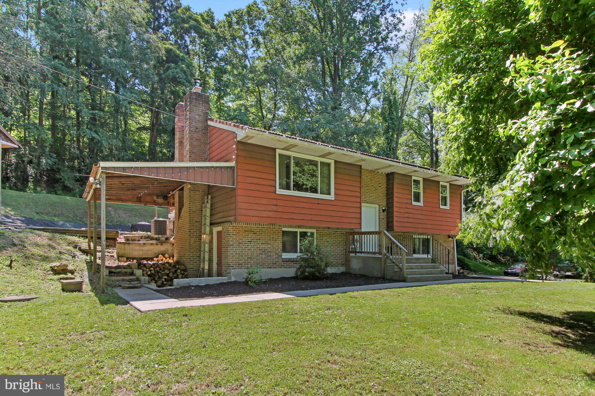 Come see this well-maintained 3 bedroom 1 and a half bathroom home with plenty of privacy in Oley School District on almost 3 ACRES! Immediately entering the home you will notice the large living room with hardwood flooring throughout, neutral paint, and a large brand new picture window that creates lots of natural light throughout the home and a view of the private yard.  Continuing on is a huge kitchen with tons of cabinetry and counterspace, a dining area, and a new sliding glass door that leads out to the covered patio, which is perfect for entertaining or enjoying your wooded backyard with the relaxing sounds of the water running from the spring house to the creek. This floor also features two spacious bedrooms and a full bathroom. Walking down to the lower level you enter into the family room that has been completely renovated with fresh paint, new flooring, and new drywall with a stone fireplace complete with a new wood mantle, new chimney liner and new stone work. The renovated third bedroom is spacious with great closet space and plenty of natural light from the new large window. The half bathroom on this level has also been completely redone with tile flooring and an upgraded vanity. There is also a laundry area/utility area and access to the one car garage. Other notable features of this home are brand new windows throughout the entire house (2020), new water tank (2018), new oil tank (2017), and a new garage door (2018). The Seller is requesting highest and best offers by the end of the day on Wednesday 6/23.