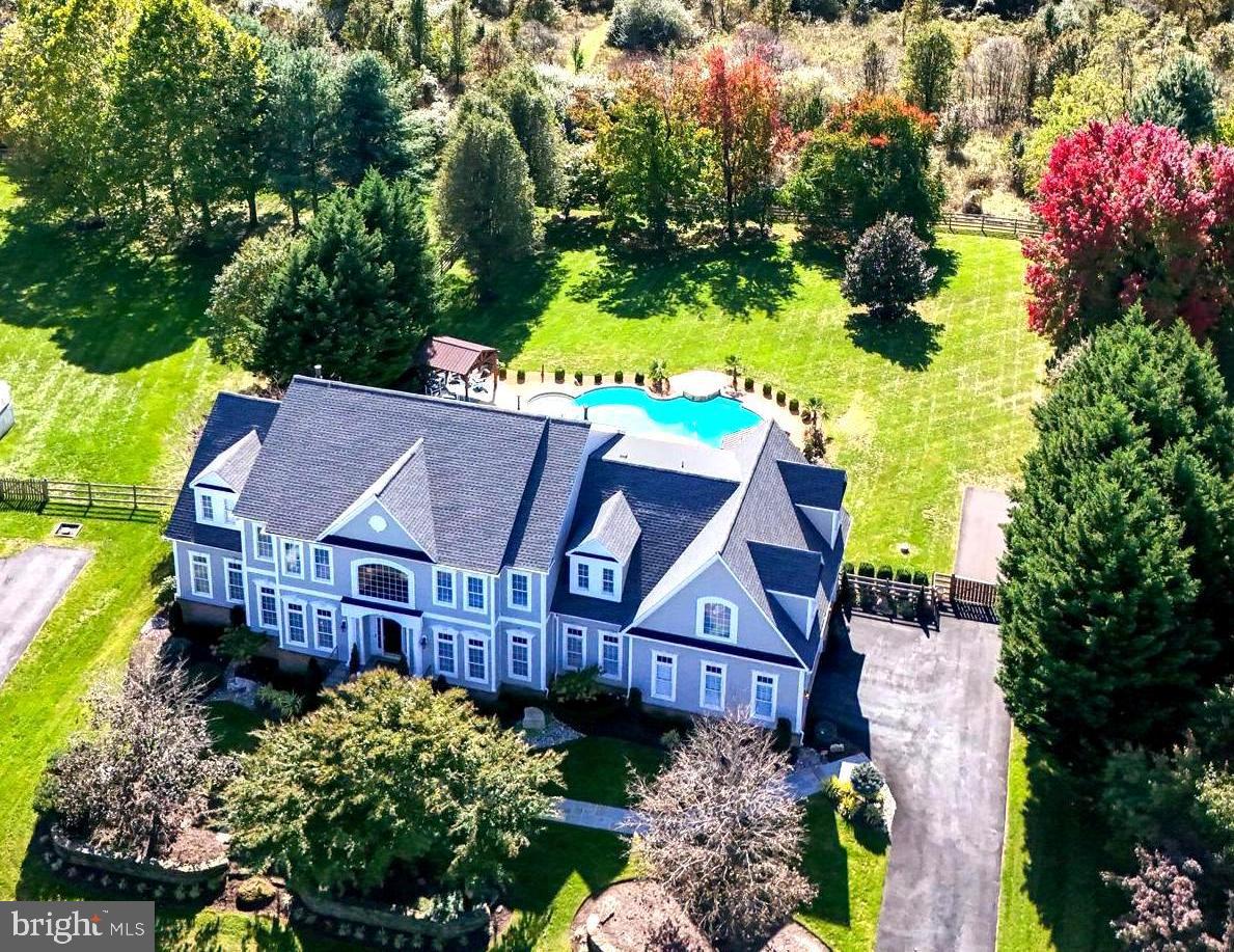 WOW! This stunning home in Raspberry Falls checks all the boxes. Over $500,000 has been invested in the past two years, including a fully renovated kitchen, a spa-like primary bathroom, all new updated secondary bathrooms, beautiful flooring throughout, modern elegant lighting, new interior doors, an elevator was added, plus a converted salt-water pool with all new equipment. The list goes on and on.

This home provides the perfect backdrop and location for years of memory-making with family and friends around the incredible entertaining spaces: a gorgeous renovated kitchen, a large family room with a stacked-stone gas fireplace, a lower level with a full wet bar and media room with theater seating, and a recreation room that is perfect for games. Of course, there’s also the new salt-water pool with sunny deck space and shaded lounging areas!

Inside, the kitchen acts as the heart of the home, featuring new cabinetry, quartz counters, fixtures, and lighting, while being open to the large family room with a stacked-stone gas fireplace. The home office near the kitchen is served by one of two main-level powder rooms. An elevator accommodates empty nesters & multi-generational living, taking owners and guests from the main level to the upper bedroom level. A spacious dining room accommodates extended family, while a large side solarium is perfect for reading, hobbies or simply conversation while soaking in natural light that pours through three walls of windows.
The upper level offers five generously sized bedrooms and four full baths. The large primary bedroom features an extended sitting area warmed by a cozy gas fireplace flanked by built-in shelving. The en-suite primary bath was fully renovated last year with an oversized seamless glass shower with tile surround, a free-standing soaking tub, a new double-bowl vanity, new interior glass doors, and a large linen closet.
The second and third bedrooms are also generously sized and each has its own private en-suite bathroom, while the fourth and fifth bedrooms share a Jack-and-Jill bath with a double-bowl vanity.

The lower level offers incredible entertaining spaces, including a wet bar, a full theater room with professional seating, a large recreation room, a den (which could serve as a sixth bedroom), and a fifth full bathroom.

This home is perfectly situated on a quiet cul-de-sac, just a short walk or golf cart ride to the Raspberry Falls Golf and Hunt Club clubhouse. It is located 10 minutes from charming historic downtown Leesburg with its vibrant restaurant and brewery scene. This location offers incredible convenience and sits at the gateway to western Loudoun County, with numerous award-winning breweries, wineries, parks, recreational venues, Potomac River access, and excellent proximity to the W&OD Trail, plus the C&O Canal Trail along the Potomac River. Reston, Herndon, and Dulles International Airport are all within a 30-minute drive. Enjoy the quiet yet convenient location and the natural beauty that envelops one of the most sought-after communities in Northern Virginia!