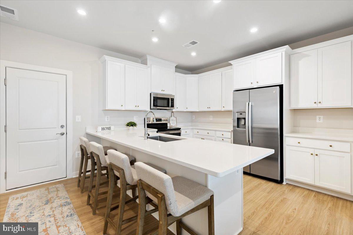 Motivated Seller! A True Gem, this beautifully Move In Ready, light-filled condo features an open layout with modern finishes throughout. Private and located near the large court yard! The main level offers 9-foot ceilings, wide-plank flooring, recessed lighting, and a spacious living area that flows into the stylish kitchen with quartz countertops, 42-inch cabinets, stainless steel appliances, breakfast bar seating, and a large walk-in pantry.
Upstairs, the spacious primary suite includes a walk-in closet and private bath with quartz countertops and a walk-in shower with built-in seat. Two additional bedrooms offer dual closets and upgraded lighting, with one featuring access to a private deck. A second full bath and upper-level washer and dryer add convenience.
Additional highlights include a one-car garage, private driveway, and extra parking. Ideally located minutes from Innovation Station Metro, Village Center shopping and dining, Downtown Herndon, Route 28, Fairfax County Parkway, the Dulles Toll Road, and Dulles International Airport.