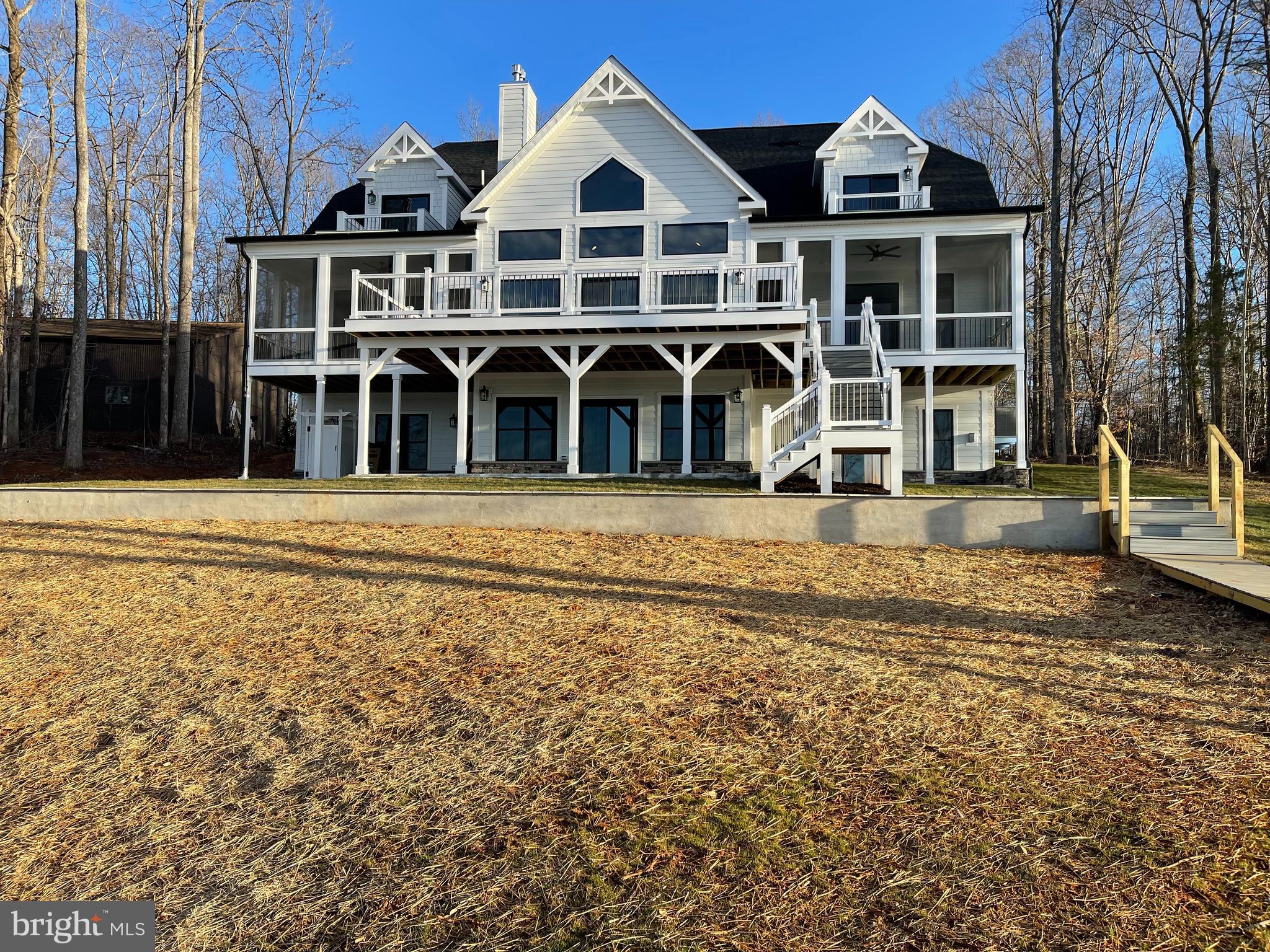 ROCK ISLAND LANDING, LAKE ANNA'S NEWEST SUBDIVISION

The residence is currently in the final stages of project completion, and this stunning waterfront home, nestled in a private paradise, is set to be finished in early October of 2023. This exceptionally unique waterfront abode offers the epitome of a beautiful custom home, providing an ideal escape in the heart of Virginia. Envision living your dream in an estate surrounded by natural beauty on the shores of one of Virginia's largest lakes.

Situated perfectly on a majestic 1.01-acre lot in Lake Anna, Louisa County, this custom home boasts 115 feet of breathtaking waterfront. The setting is idyllic, featuring a flat, comfortable elevation that offers stunning views, perfect for a walkout basement and captivating sunset views. Enjoy direct lake access and a beautiful private yard.

No detail, whether grand or small, was overlooked in the design and construction of this absolutely stunning home. With over 6,125 square feet of living space on all three levels, it encompasses 7 bedrooms, 5 full baths, one half bath, 3-stop elevator shafts, two screened porches, a sundeck, and two balconies on the third level.

The main level welcomes you with an open floor plan boasting 10' ceilings. The great room and dining area feature a dramatic two-story ceiling flanked by screened porches and a deck, perfect for large-scale entertaining. The modern-styled kitchen is equipped with premium stainless steel appliances and quartz countertops.

The luxuriously appointed master suite on the main floor includes a stunning master bath with marble tiles, a freestanding bathtub, a luxurious shower, and a private screened porch overlooking the lake. Two spacious bedrooms with a full bath, one featuring a private screened porch, and 1st-floor laundry complete the impressive main floor living space.

The upper level features a two-bedroom suite with one full bath and one balcony for each room overlooking the lake, with 9ft high ceilings. The expansive lower-level walkout boasts outstanding recreation space with a full kitchen/bar, 2 additional bedrooms, a media room, and a fireplace. Multiple decks, screened-in porches, and luxurious finishes enhance the entire home.

There is still time to personalize this home to make it uniquely yours. Select interior and exterior features such as stone, Hardie, colors, upgrades, and an optional elevator. Situated on the private side of Lake Anna, this property is scheduled for completion in early October 2023. For more information on other floor plans and waterfront lots, please contact the real estate agent. NOTE: The pictures accompanying this listing are representative of the quality of work and the features and upgrades available to the buyer.