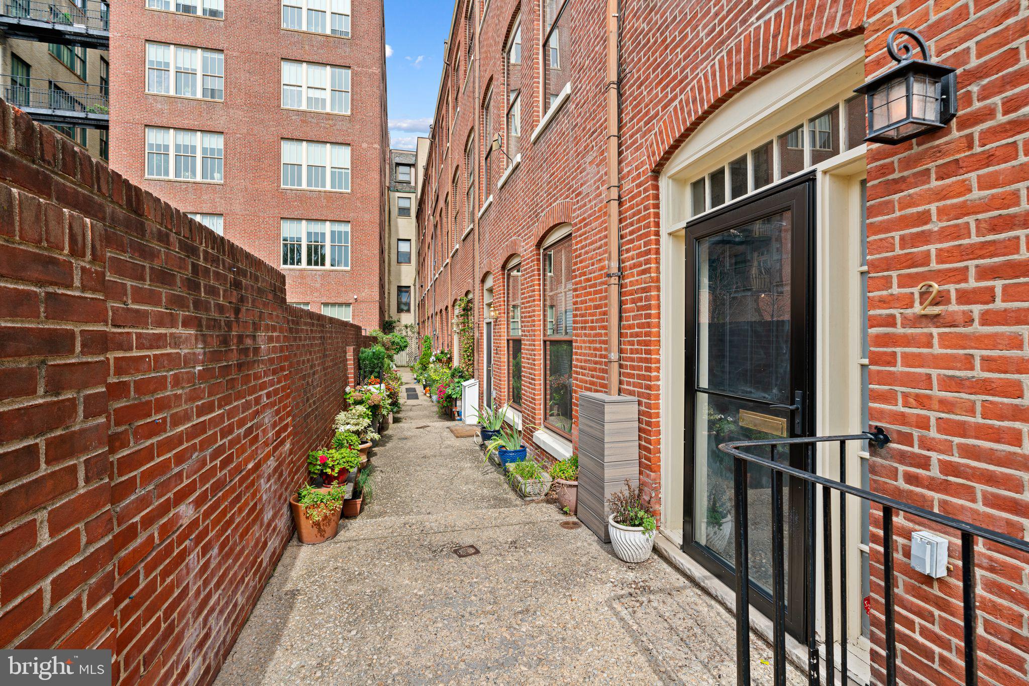 Welcome to 2 Willings Alley Mews! Located in the heart of Society Hill on historic Willings Alley, this gorgeously renovated and well maintained 3 Bed/2.5 Bath townhome with 1-car deeded parking is the perfect blend of old world charm and modern living. As you enter the parking area, and through the secure gate into the common area courtyard with patio, you'll notice how well-maintained and quiet this community is.

As you enter the welcoming foyer, you'll notice ample closet storage and open concept living/dining spaces that boast 9+ foot ceilings. There is also a renovated half bathroom, wood-burning fireplace with white quartz mantel and black arabesque tilework, additional storage, and custom woodwork throughout.   The floors were also treated in 2024 for added traction while walking throughout the home and up/down the stairs.

The lower level is accessed by an open staircase which allows for plenty of natural light. This level features custom built-ins, beautiful 'brick barrel' ceilings, a family room & den space with potential for a home office set up. The beautiful chef's kitchen is equipped with a professional grade Bertazzoni Italia six-burner gas range, electric convection oven and stainless steel range hood. There is also a large stainless steel sink, Samsung French door refrigerator, and a KitchenAid dishwasher. The wet/coffee bar contains a mini-sink and a 44 bottle two-zone wine cooler.

The second level of the home was completely reconfigured and renovated in 2021 which includes two bedrooms with engineered hardwood floors, a fully updated bathroom with double vanity, shiplap woodwork, and shower/tub combination. There is also a desk/vanity area with newer cabinetry in between the bedrooms as well as a hall laundry closet with a sliding barn door to round out the 2nd floor.

Moving upstairs to the third floor, you'll find the primary bedroom which is bright, airy and spacious with a full wall of mirrored closets and a separate HVAC system. The en-suite bathroom includes a large walk-in shower with a rock floor tile and a Jacuzzi soaking tub. There is additional storage in the stairwell leading to the roof deck and the rooftop deck was renovated in 2023 with new Trex decking, railings, lighting and siding. From here you'll enjoy views of Old City and the fireworks at Penn’s Landing!

Situated in the Highly Rated McCall School Catchment and just steps from Penns Landing, Washington Square, historical sites, public transportation, nightlife, access for commuting in/out of the city and much more, 2 Willings Alley Mews is truly a must-see home!