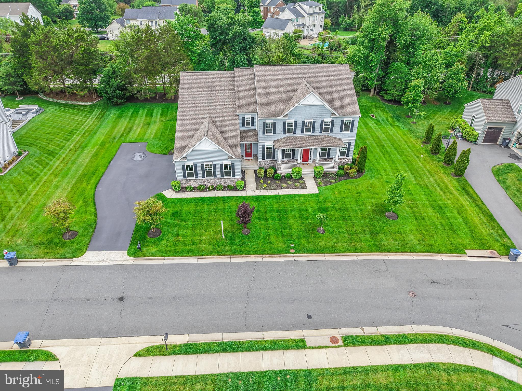 Fantastic opportunity for multigenerational living with main level bedroom and full bathroom!  Situated on a premier 0.57-acre cul-de-sac lot, this 2019-built estate offers an unparalleled living experience spanning over 8,100 square feet of meticulously designed space. The residence makes an immediate impression with its commanding Colonial silhouette and side-load three-car garage, opening into a gallery-inspired interior defined by light oak wide-plank flooring, matte black accents, and soaring ceilings. The heart of the home is the great room, where a floor-to-ceiling black marble fireplace serves as a stunning focal point, framed by a wall of windows that flood the home with natural light and invite the outdoors in. The kitchen is a masterclass in contemporary design, equipped with sleek cabinetry, premium quartz countertops, and a massive waterfall island that transitions seamlessly into the open-concept living areas. Designed for the modern lifestyle, the main level includes a versatile bedroom with a full ensuite bath, ideal for visitors. Upstairs, the primary sanctuary serves as a true retreat, boasting a spa-inspired bath with a freestanding soaking tub, a seamless glass shower, and dual designer vanities. Every secondary bedroom is a private oasis, each thoughtfully paired with its own beautifully appointed ensuite bathroom to ensure comfort for family and guests alike. The home’s lifestyle potential extends to the expansive walk-up lower level, a versatile space perfectly suited for a state-of-the-art home theater, private gym, or recreation space and ability to finish space for an additional 6th legal bedroom.  The double-wide doors invite an abundance of natural light into the space. Outside, the flat backyard opens to a deck with custom lighting and offers a rare level of privacy and a blank canvas for a custom pool, pavilion, or outdoor kitchen. Meticulously maintained and featuring high-end upgrades such as a comprehensive water treatment system and sprinkler system, this property offers the peace of mind of recent construction. Located just minutes from the Silver Line Metro, Reston Town Center, and the Dulles tech corridor, this is a rare opportunity to own a modern masterpiece in the heart of Herndon’s most sought-after landscape.
