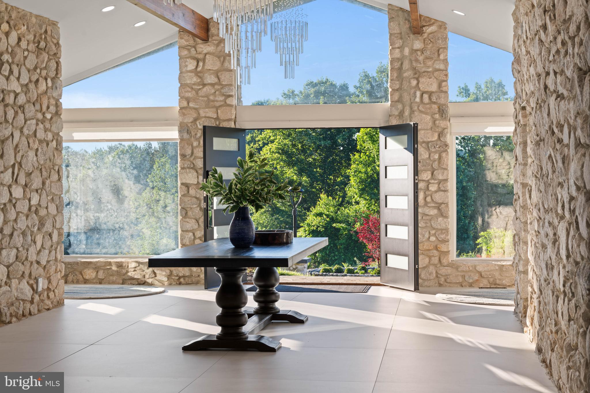 A sprawling stone ranch set on 10.6 private acres, designed for casual living, gathering, and unwinding. Natural materials define the interior, where vaulted ceilings, stone walls, wood-burning fireplaces, and expansive windows create a constant connection to the landscape and stellar views.
Main level provides true one-floor living. Generous great rooms and a spacious kitchen designed for serious cooking and effortless entertaining. A primary suite enjoys its own deck overlooking the grounds, a custom-fitted closet and infrared sauna. The fully equipped lower level—with kitchen, living spaces, bedrooms, baths, and laundry—offers exceptional flexibility for in-laws, extended family, guests, or independent living arrangements.
Thoughtfully planned outdoor living creates a private retreat monitored by exterior security system. Huge saltwater pool with lounging shelf and auto cover, hot tub for 6 with blue tooth controls, covered outdoor kitchen area, firepit lounge, pergola, basketball court, and playground offer destinations throughout the property, while open land provides room for horses, gardens, and future ambitions.
A truly unique lifestyle opportunity. Major recent renovation since 2024 provides updated systems, conveniences, and efficiency: Roof, HVAC systems, Security, Insulation, Soundproofing, Second Well yielding 8gpm, Updated Electric and Plumbing, New Appliances. Smart Lock/Doors. Outdoor Living. Conveniences under 10 minutes to Fallston’s Ace Hardware and Restaurants or downtown Jacksonville. 5 Minutes for pizza and subs at Palmisanos in Baldwin. 15 minutes to downtown Jarrettsville. Explore nearby Gunpowder State Park for hikes and trails, Boordy Vineyards, Prigel Family Creamery for ice cream and local dairy, Ladew Topiary Gardens, the Polo Fields, Manor Tavern, and local farms for produce and flowers. Xfinity Internet. ****DO NOT ENTER PRIVATE DRIVE WITHOUT APPOINTMENT****