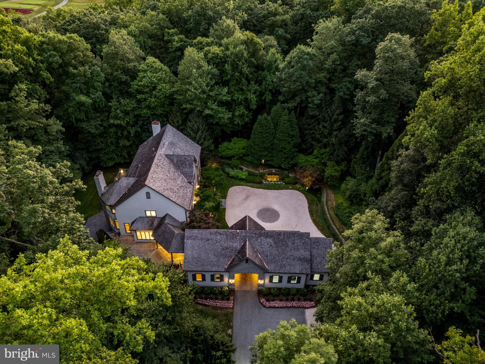 Welcome to this breathtaking and fully renovated custom-built estate nestled in the prestigious Residences of Caves Valley Golf Club, overlooking the green of the signature par 3 - 3rd hole. As you enter through the barrel-vaulted archway, a grand estate drive unfolds, leading to a meticulously landscaped motor court, adorned with lush gardens, a tranquil water fountain, and a flagstone walkway that guides you to the stunning main entrance. Inside, a two-story foyer with a graceful oak staircase introduces you to the elegance and sophistication that defines this luxury home. The main level boasts quarter-sawn oak floors and high ceilings throughout, beginning with an expansive living and dining room, where oak architectural details, a wood-burning fireplace, and built-in bookcases create a warm, inviting atmosphere. The gourmet kitchen, equipped with top-of-the-line Bosch appliances, a Viking range with six burners and a griddle, and a Monogram wine fridge, is a chef's dream. The quartzite glass backsplash adds a modern touch, while the walk-in pantry provides ample storage. Adjacent to the kitchen, the sun-drenched breakfast area flows seamlessly into the Family Room, featuring a beamed ceiling and a second fireplace, perfect for cozy gatherings. The main level also includes a private two-story guest bedroom or au pair suite with a full bath and a second-level sitting area ideal for extended family or guests. A home office or playroom, mudroom with cubbies, and a second office provide versatility for modern living. Upstairs, the sumptuous primary suite is a true retreat, featuring a fireplace, two custom-fitted dressing rooms, and a spa-like bath with marble heated floors. Two additional en-suite bedrooms, one with a spacious third-floor loft, offer comfort and privacy. The lower level is an entertainer’s paradise, complete with a rec room with a wet bar, a media room, a game room with a fireplace, a full bath, and a potential gym. Outside, the expansive Ipe hardwood deck, stone patio, and terrace provide multiple areas to enjoy the serene surroundings. The professionally landscaped 3.75-acre lot includes a herb garden, and there’s space for a future pool or even a par-3 golf hole. The home also features a three-car garage with epoxy floors and cedar shake exterior, adding to its timeless appeal. Whether relaxing in the primary suite, enjoying the designer lighting, or envisioning future outdoor possibilities, this reimagined estate offers a lifestyle of unparalleled luxury and sophistication. Caves Valley Golf Club Residences offers an extraordinary lifestyle that combines the allure of luxury living with the beauty of a world-class golf course. Live in an exclusive community in a coveted destination. Imagine stepping out of your home and onto the greens for a round of golf at your leisure. Whether you are an avid golfer or simply appreciate the beauty of an exquisite community, this extraordinary living destination provides an unrivaled experience.