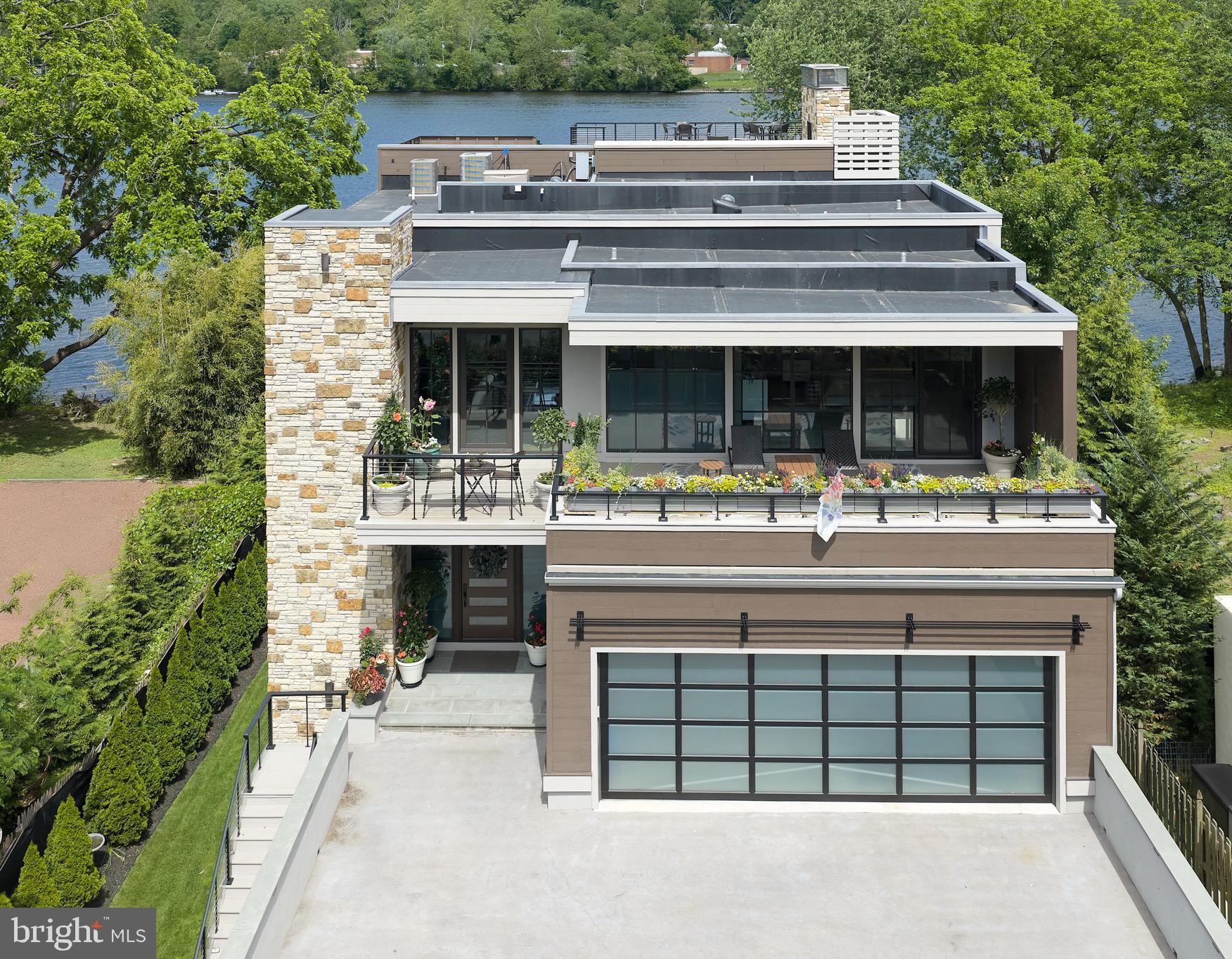 Modern Riverfront Estate with Unparalleled Indoor-Outdoor Living

Welcome to 182 S. Main Street, a rare opportunity to own one of New Hope’s few new-construction riverfront estates. Built in 2021 with every luxury in mind, this architectural showpiece blends cutting-edge design with the timeless allure of life along the Delaware River.

From the moment you enter the two-story foyer, you’re met with sweeping river views that flow throughout the home’s open living spaces. The main level features radiant-heated floors, a chef’s kitchen with  Sub-Zero refrigerators, wine refrigerator, and Wolfe gas stove and double ovens with warming drawer, plus a wet bar with sink, refrigerator, and ice maker—ideal for entertaining in every season. The adjoining family room opens to a spacious riverfront terrace, creating an effortless connection between indoor and outdoor living that is truly unparalleled. Additionally there is a half bath and laundry on the main level. 

The primary suite on the main level serves as a private retreat, complete with two large walk-in closets—one showcasing a sparkling chandelier and built-in TV for a touch of glamour—along with a spa-inspired bath.

Upstairs, you’ll find three additional bedroom suites, each with a private bath, as well as a dedicated office and an expansive family/media room with bar and an additional half bath and laundry. The upstairs bathrooms feature radiant-heated porcelain floors, and the family room boasts a 100-inch drop-down screen, wet bar with ice maker, microwave, refrigerator, and dishwasher, and panoramic river views. This versatile upper level can function as a private living area for family or  guests, with both front and rear terraces extending the space outdoors. 

The home’s roof deck offers one of New Hope’s most exceptional outdoor living experiences—a dramatic vantage point complete with a fireplace and unrivaled views of the river and fireworks, making it one of the area’s most spectacular private spaces.

The lower level continues the sense of luxury with 10-foot ceilings and radiant-heated floors throughout. The media and game room opens to a covered patio with built-in heaters and a private hot tub overlooking the water. From here, a floating dock provides direct access for boats and two jet skis, making river recreation effortless.

Car enthusiasts will appreciate the innovative car-lift system connecting the main-level garage to the lower level, accommodating four vehicles below, one on the lift, and two in the main garage—plus parking for five additional cars in the driveway. A large storage space beneath the driveway provides ample room for summer gear, river toys, and seasonal décor. There is also an additional storage space that has a garage door to the backyard, great for bringing water toys in or versatile storage space. 

Additional features include:
• Fully integrated smart-home system controlling lights, shades, and sound throughout
• Hardwired indoor and outdoor speaker system
• Professionally landscaped riverfront grounds

With its unmatched combination of design, technology, and river access, 182 S. Main Street stands as one of New Hope’s most remarkable modern estates—offering unparalleled indoor-outdoor living just steps from the heart of downtown.