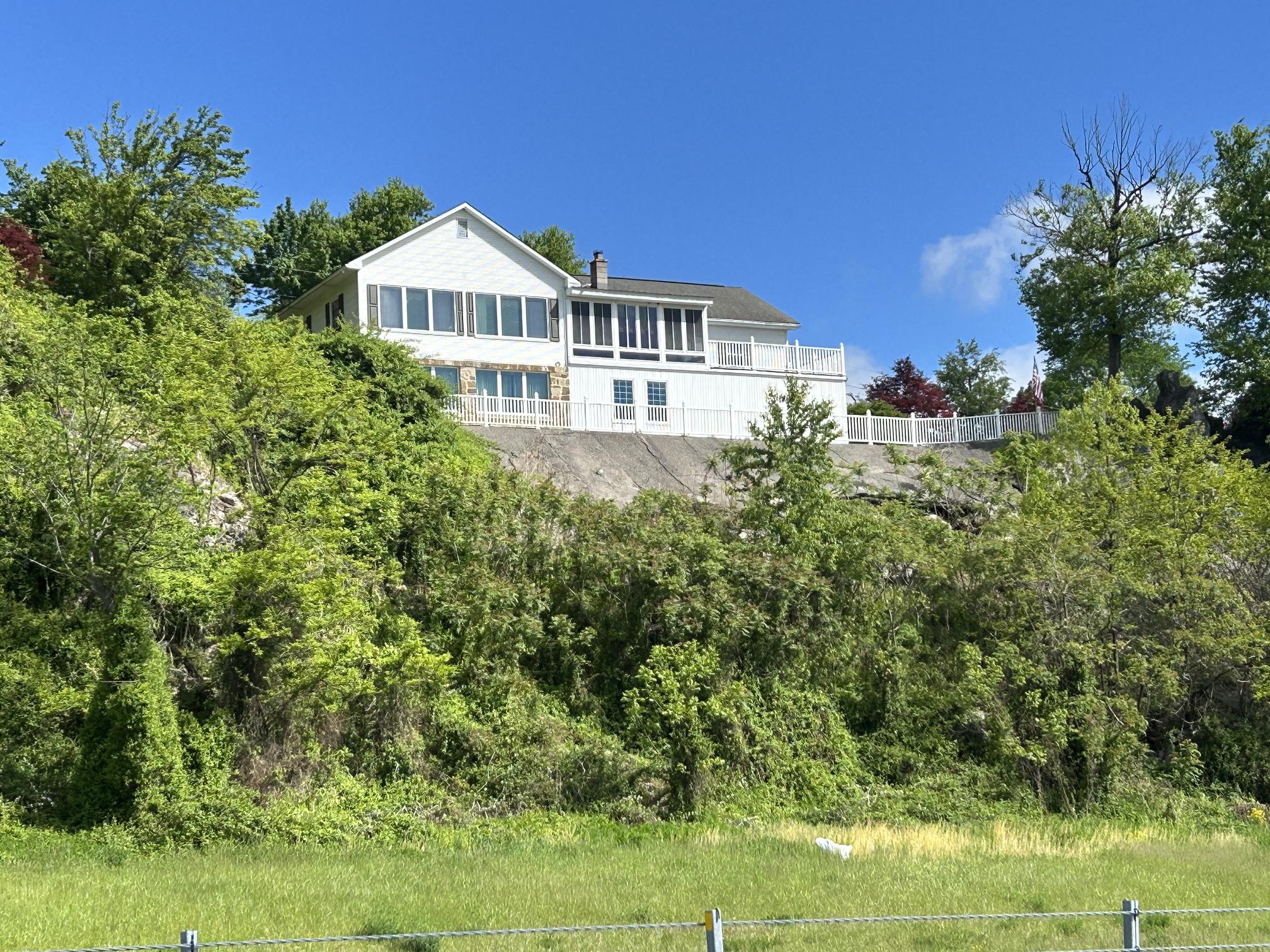 You’ve seen it from Route 522—now is your chance to own it. This one-of-a-kind ranch home sits on 1.78 private acres and delivers some of the most breathtaking mountain and downtown views in the area, complete with the legendary Prospect Rock right on your property.The main level boasts 1,296 square feet of thoughtfully designed living space, anchored by an expansive living room featuring a stunning wall of windows. An adjacent enclosed sunroom provides an ideal vantage point to enjoy the panoramic scenery year-round. The main floor also hosts a large kitchen and dining combination with beautiful walnut cabinetry, alongside a peaceful primary bedroom and full bath.
The daylight lower level dramatically expands the home's footprint, offering a spacious recreation room with scenic views, an additional bedroom, a flexible office or third bedroom, and a second full bath. A dedicated laundry room and a versatile bonus area—perfect for hobbies, a home gym, or a playroom—complete this level.
Car enthusiasts and hobbyists will appreciate the two integral garages with a workbench area, easily accessed via the paved driveway. Two additional storage sheds provide ample space for equipment. This is a rare opportunity to own a truly distinctive Lewistown landmark that effortlessly combines privacy, functionality, and unparalleled views.