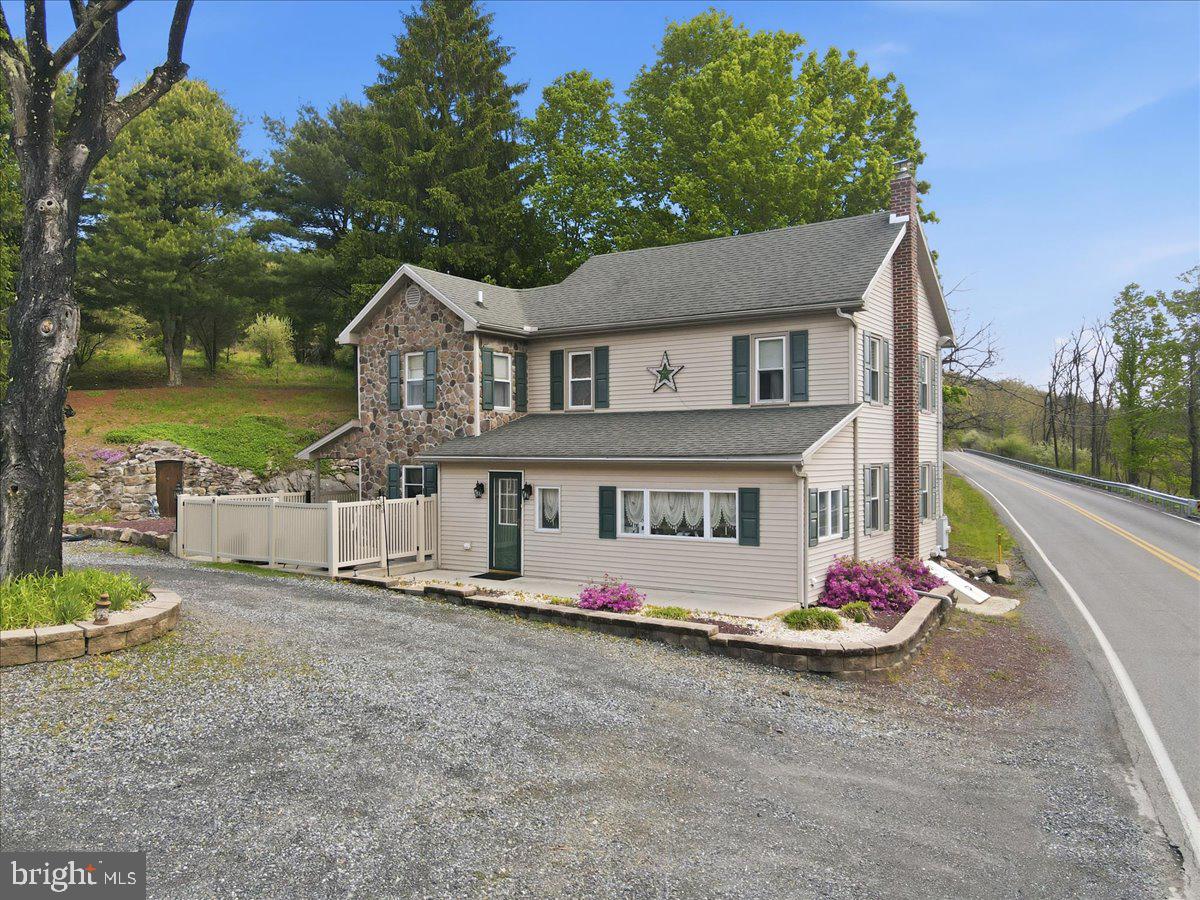 Nestled on over 10 acres of serene, partly wooded land, this charming farmhouse-style residence offers a perfect blend of rustic charm and modern convenience. If you have a dream of homesteading or having a farmette, this is the property for you! Built in 1900, the home has been thoughtfully updated while retaining its original character, making it a warm and inviting retreat. Step inside to discover a traditional floor plan that flows seamlessly from room to room. The heart of the home features a cozy living area complete with a propane fireplace/stove, perfect for gathering with loved ones on chilly evenings. The country kitchen is a chef's delight, equipped with stainless steel appliances, including a double oven and built-in microwave, ensuring that meal preparation is both efficient and enjoyable. The adjacent formal dining room provides an elegant space for entertaining, while the main floor laundry adds convenience to your daily routine. With three spacious bedrooms and two and a half bathrooms, this home offers ample space for relaxation and privacy. Each bedroom is designed to be a peaceful sanctuary, with plenty of natural light and comfortable carpeting underfoot. The bathrooms are well-appointed, featuring modern fixtures that enhance the home's overall appeal. Outside, the property is a true oasis. Enjoy summer barbecues using the custom built BBQ which features a mural of the landscape or relax on the inviting porch while taking in the stunning mountain views. The expansive lot features beautifully landscaped areas, a gentle slope, and a charming stream, creating a picturesque setting for outdoor activities or simply unwinding in nature. Additional structures, including a detached garage and shed, provide ample storage and workspace for hobbies or projects. Located in a tranquil rural setting, this home offers the perfect escape from the hustle and bustle of city life while still being conveniently accessible. This property is not just a house; it's a place to create lasting memories. Whether you're looking for a peaceful retreat or a space to entertain, this home has it all. Embrace the opportunity to own a piece of tranquility, where comfort and nature come together beautifully.