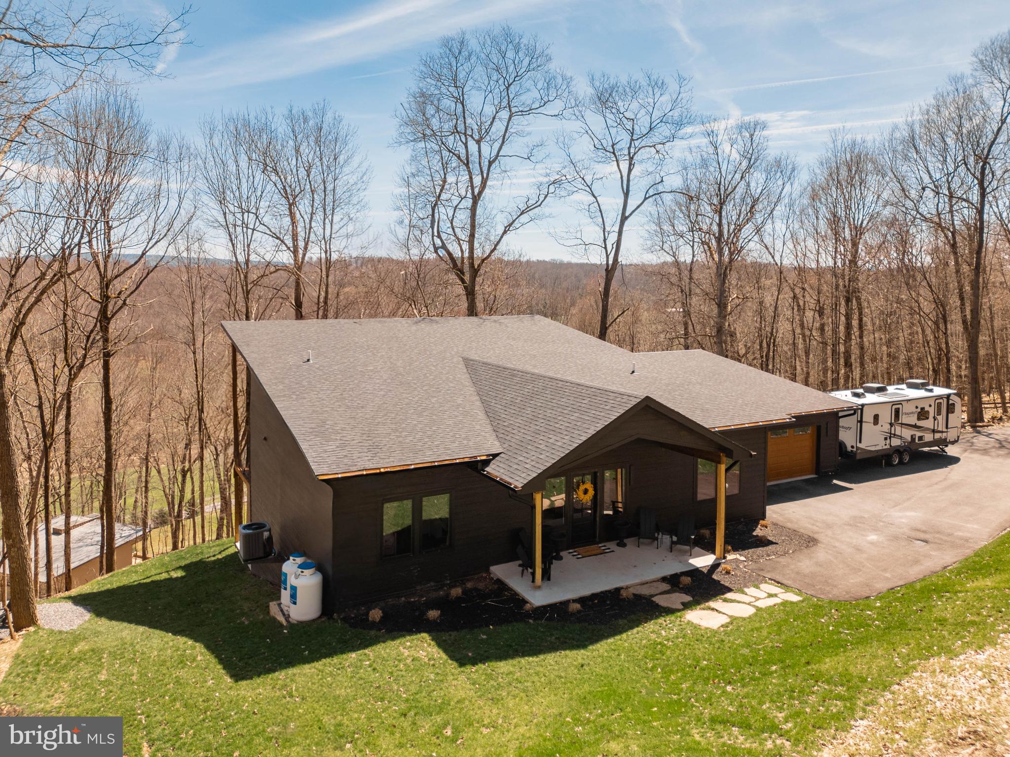 This stunning, recently built 4+ bedroom, 3.5 bath home in Country Club Acres offers modern design, thoughtful upgrades, and unmatched privacy on 3.43 wooded acres perched at the top of the mountain overlooking Oakland Golf Course and multiple ponds. The bright, open-concept layout is filled with natural light and features commercial-grade LVP flooring throughout, complemented by mid-range, handpicked finishes selected by the designer/builder for a cohesive and stylish look with room for personalization. The gourmet kitchen showcases KraftMaid cabinetry, quartz countertops, and a full backsplash, while multiple ensuite bedrooms provide comfort and flexibility. Additional highlights include a fireplace, Andersen windows and sliding doors, and a fully finished basement with 10-foot ceilings providing exceptional additional living and recreation space. Enjoy outdoor living with a massive covered deck and lower patio, along with a paved driveway, oversized 2-car garage, 30-amp RV connection, tankless hot water system, water treatment system, and professionally installed sod with a fire pit. Located in the desirable Country Club Acres community with no HOA, this home offers easy access to town amenities, parks, trails, the Youghiogheny River, and Herrington Manor and Swallow Falls State Parks, delivering a perfect blend of move-in-ready comfort, scenic beauty, and long-term potential.