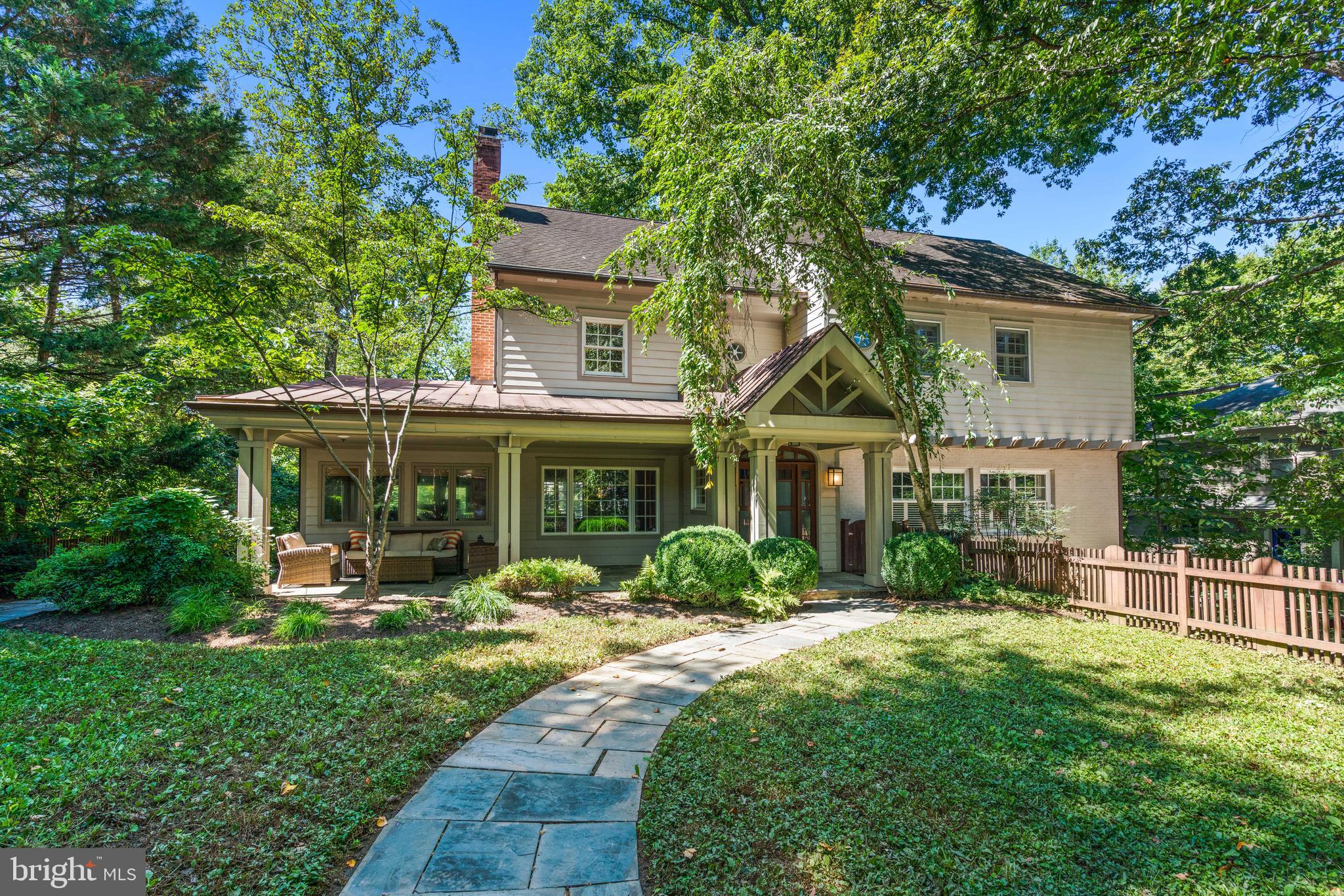 Sited on a private lot in the heart of Glen Echo Heights, 5128 Wissioming Road shines with light-filled contemporary design, dramatic fixtures, and thoughtful details throughout. Delivering 5,000+/- square feet across four finished levels, this 6-bedroom, 4 full and 2 half baths home combines generous proportions with intimate spaces. Finer details include oversized windows, crown and decorative moldings, hardwood floors, and two fireplaces. Multiple outdoor spaces extend the living, providing both serene retreats and entertaining backdrops.
A charming front gate and flagstone walkway lead to a covered front porch that opens into a foyer with high ceilings and an elegant flow. Sunlit living and dining rooms anchor the main floor, complemented by a home office with wood-paneled ceiling and built-ins, a powder room, and a gourmet kitchen with center island and breakfast bar open to the spacious family room. From here, step onto the back deck or down to the expansive patio surrounded by mature landscaping for privacy and quiet gatherings.
The second floor is home to the primary suite, complete with private sitting room, custom walk-in closet, and updated en-suite bath with dual vanities. Two additional generously sized bedrooms with walk-in closets, a hall bath, and laundry complete this level. Need more space? The third level is outfitted with three bedrooms, another full bath with dual sinks and two toilets, along with abundant storage space. The walkout lower level includes garage access via a private entrance, a recreation room, a large storage area, and another full bath.
An attached two-car garage and private driveway add convenience, while the setting places you just a short stroll from the Potomac River and Glen Echo Park. Glen Echo Heights itself is known for its tree-top canopies, trails, and close-knit feel, plus a neighborhood park with playground, basketball court, and multi-use field. With easy access to downtown Bethesda, Friendship Heights, NW D.C., and major commuting routes, this home delivers the best of both: a secluded retreat in a supreme location.  All square footage estimates are believed to be reliable but are not guaranteed.