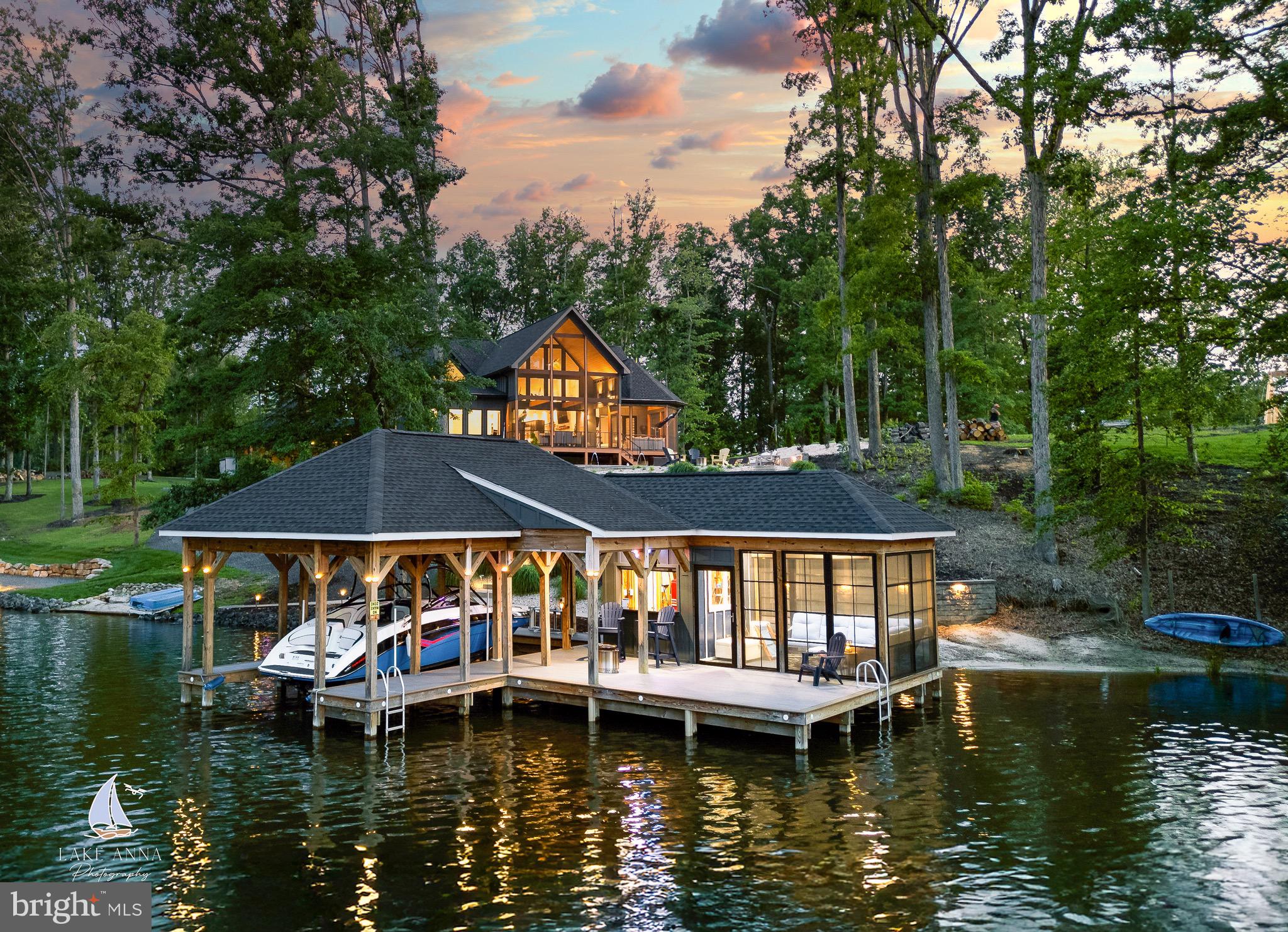 Live the Dream: Waterfront Luxury with Private Pool at Lake Anna.

Welcome to the lake life—where every day feels like vacation. At 2 Wolftrap Ct on the private side of Lake Anna, Virginia, you’ll find the ultimate fusion of lakefront living and resort-style luxury. With your own private pool, deep-water dock, and designer interiors, this custom home delivers a lifestyle you simply won’t find anywhere else.

This 3-bedroom, 2.5-bath modern masterpiece offers approximately 2,500 square feet of thoughtfully designed living space. As you arrive, an upgraded concrete driveway welcomes you to a beautifully integrated carport and single-car enclosed garage, both connected to the main home by a stylish breezeway with a rich wood ceiling—providing not only protection from the elements, but a seamless architectural finish.

Step inside to soaring wood ceilings, wide-plank hardwood floors, and a showstopping luxury kitchen outfitted with high-end appliances, custom cabinetry, and striking finishes you won’t find in any other home. A modern tile fireplace anchors the open-concept living area, where oversized bi-folding glass doors open the space to a covered, screened-in deck with lake views, wood-paneled ceiling, and a cozy outdoor fireplace—perfect for summer nights or crisp fall mornings.

Your private backyard is a retreat all its own. Lounge by the expansive custom pool (approximately 20' x 35'), entertain guests at the lakeview patio, or head to your extended trex boat dock—complete with a boat lift, covered bar area, screened-in seating, and sundeck. A retaining wall leads to your private sandy beach and a tucked-away cove ideal for swimming and relaxing. Enjoy approximately 120 feet +/- of waterfront! 

Back inside, the primary suite is a dream—featuring private deck access, a spa-like ensuite with a massive walk-in shower, modern vanity, and a custom-designed closet system. Two additional bedrooms share a luxurious Jack-and-Jill bathroom with a walk-in shower and soaking tub. One guest room connects directly to a flexible office/den with sweeping lake views, making it the perfect spot for working from home or curling up with a good book.

Homes like this don’t come around often. Experience the privacy, beauty, and unmatched luxury that only Lake Anna can offer.

Schedule your private tour today and claim your piece of paradise before it's gone.