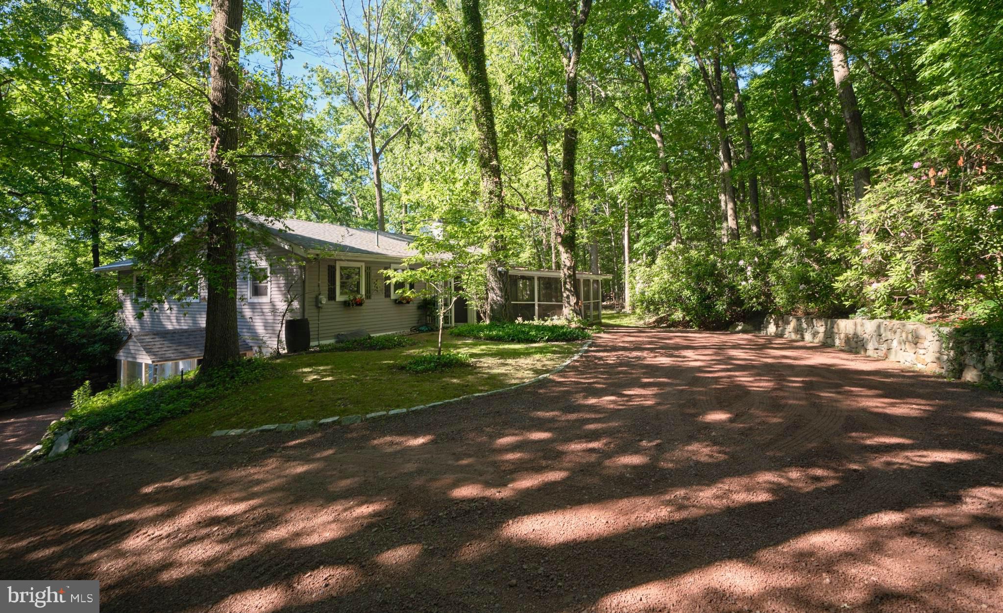 Tucked away at the end of a long private lane atop Buckingham Mountain, this charming 2-bedroom ranch offers a rare opportunity to enjoy peaceful one-floor living surrounded by nature. Set on 2.5 wooded acres, the property is a true retreat for outdoor enthusiasts, bird watchers, and anyone seeking privacy without sacrificing convenience.
Inside, you'll find an open floorplan with warm hardwood floors, and abundant natural light,  all centered around a wood-burning stone fireplace. The updated kitchen features refreshed cabinetry and countertops, while the adjoining screened porch provides the perfect place to enjoy morning coffee, evening breezes, and year-round views of the surrounding woods.
The thoughtfully designed layout includes a walk-out basement offering an additional bedroom/flex space with full bathroom, a great workshop space, or future finishing potential. Additional amenities include central air conditioning, backup generator hookup, low taxes, and a secluded setting that feels worlds away while remaining within the highly regarded Central Bucks School District, and minutes from New Hope & Doylestown!  Whether you're looking for a full-time residence or a peaceful weekend escape, this Buckingham Mountain hideaway offers comfort, privacy, and a deep connection to the natural beauty of Bucks County.