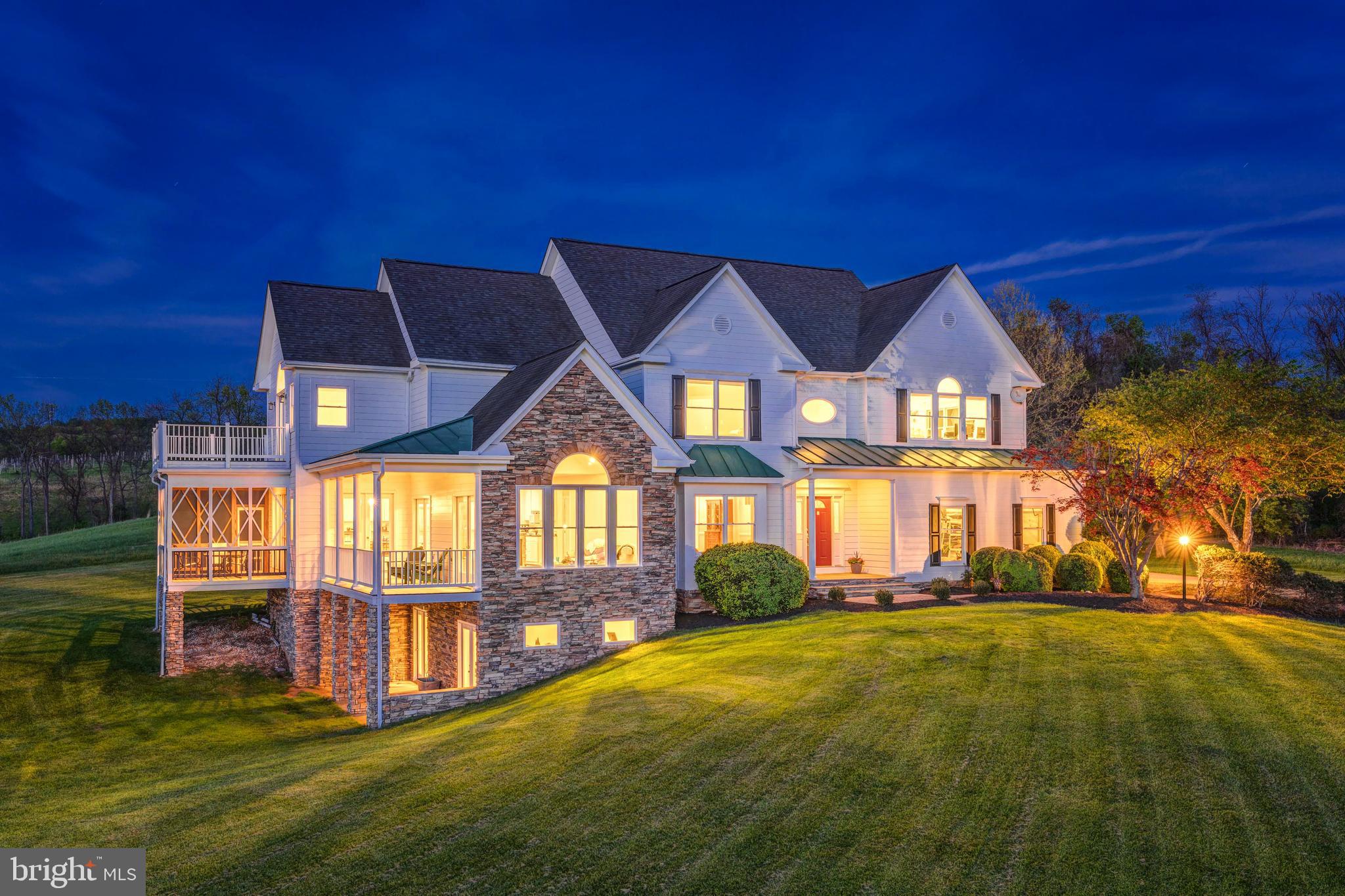 Escape to this serene 10-acre country estate in Paeonian Springs, where breathtaking west-facing sunset views create a backdrop for a truly exceptional lifestyle. This custom designed home available for the first time from its original owners, this lovingly maintained home blends contemporary updates and traditional architecture to create an airy, open layout perfect for modern living. Only 10 minutes from downtown Leesburg, life here feels like a different world, with a slower, more intentional pace of life. Approach through idyllic countryside to a side-load 3-stall garage and large motorcourt driveway welcoming you home. Enter inside to a grand two-story foyer and formal living room filled with natural light, featuring a charming window seat that frames the endless rolling-hill views. The property has been meticulously updated with freshly refinished cherry wood floors and new carpeting in 2025, plus new interior and exterior paint within the last year. The formal dining space showcases elegant moldings and a ceiling medallion, providing versatility for both grand entertaining and intimate gatherings. From here, transition directly outside or through a large mudroom to the expansive backyard. In the kitchen, all-white cabinetry complements multiple dining options, including an eat-in area and generous bar-top seating. Double doors open to the screened porch and open deck, creating seamless indoor-outdoor flow surrounded by pristine country views. Continue into the vaulted family room with cathedral ceilings and a stunning Palladian window that bathes the space in natural sunlight. The main level also features a versatile bedroom suite with a private full bath and two closets, perfect for guests or an in-law suite. Upstairs, the primary suite offers vaulted ceilings above the bedroom and sitting area, a private balcony, and two walk-in closets. The primary bath includes a soaking tub with views, double vanity, and separate shower. This level also hosts two additional bedrooms, a full hall bath with double sinks, a spacious laundry room with ample storage, and a large bonus room used as an artist's studio. The walk-out lower level provides a bright, finished space with a versatile recreation room, an additional bedroom and full bathroom, plus dedicated storage. Enjoy outdoor living on three levels: a deck and screened porch off the main level, a balcony off the upper level, and a shaded patio off the lower level. The 10-acre property includes apple trees and offers endless possibilities with land use tax benefits and no HOA. Located in Loudoun County's wine and horse country, you're just minutes from local vineyards, breweries, schools, parks, and golf courses, with diverse shopping and dining options in nearby historic Leesburg and Purcellville. The charming village of Waterford is just a short drive away. This exceptional property offers the perfect balance of private country living with convenient access to amenities. A rare opportunity to own a piece of Virginia's beautiful countryside with space to truly make it your own.  Property is in land use and Seller not responsible for roll back taxes