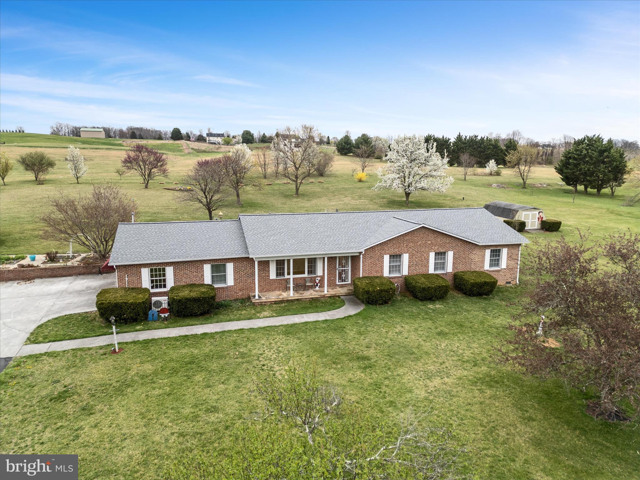 Discover your dream retreat with this charming all-brick rancher, perfectly situated on 7.47 acres of picturesque landscape, just minutes from town, shopping, and schools. This exceptional property includes an additional parcel with previously approved 1 bedroom perc, offering additional opportunity or buffer space.  Step inside to hardwood floors and an traditional layout that boasts a spacious primary suite with walk-in closets and a primary bath featuring a walk-in shower. Stainless steel appliances and corian countertops top the kitchen highlights, with an island and bar seating and ample cabinet space.   Additional generously sized bedrooms provide comfort and versatility for family and guests.
The massive den is perfect for cozy gatherings, while the sunroom, with gorgeous stone floors,  steals the show with stunning views of the landscaped acreage and courtyard garden.  There is even a small portion of the yard fenced, convenient for pets!
Outside, take advantage of the detached two-car garage, two powered sheds, an additional powered garage with two additional garage bays and workshop area, and a charming gazebo ideal for relaxing in the shade.  Whether you’re hosting gatherings or savoring quiet moments, this property offers endless possibilities. Don’t miss your chance to own this serene oasis—schedule your private tour today and experience country living just moments from modern convenience. Please Note: home has an HVAC system for heat and air.