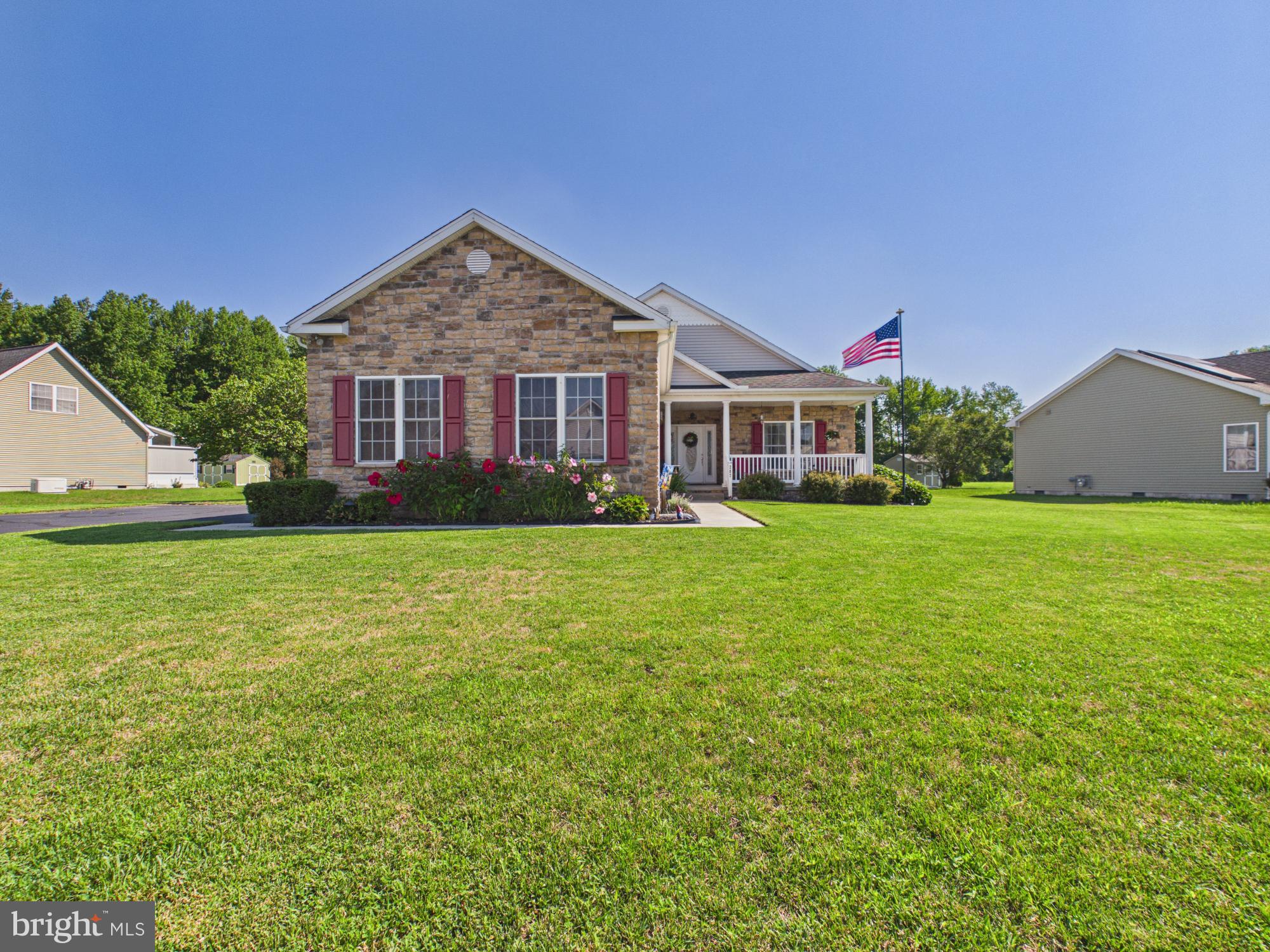 Set on a beautifully landscaped 0.26-acre corner lot in the quiet Breeders Crown Farms community, this 3-bedroom, 2-bath single-level home offers 2,098 square feet of comfortable, easy living with open farmland and mature trees just beyond. A stone-and-siding façade, covered front porch, and manicured lawn welcome you home before you ever step inside.
Through the front door, the vaulted great room is the heart of the home, anchored by a floor-to-ceiling stone gas fireplace and warmed by natural light from a wall of French doors. Those doors open to a bright, tiled sunroom/flex space with its own access to the backyard.
The eat-in kitchen is built for gathering, featuring rich oak cabinetry, stainless steel appliances, a tiled backsplash, and a center island with breakfast-bar seating. It flows naturally into a dedicated dining area, making everyday meals and holiday hosting equally effortless.
The spacious primary suite is a true owner's retreat, complete with a tray ceiling, a private en-suite bath with dual vanities, and not one but two walk-in closets. Two additional bedrooms and a versatile office/flex room provide room for family, guests, and everything in between.
Practical touches make daily life simple: a dedicated laundry room, a walk-in pantry, and an oversized 2-car garage. Upstairs, a large walk-up attic offers exceptional storage — or the opportunity to finish it into additional living space down the road. Peace of mind comes built in with a brand-new HVAC system installed in 2025, plus the convenience of public water and sewer and efficient natural gas heat.
Out back, a flagstone patio and storage shed sit on a level, open lot perfect for entertaining, gardening, or simply enjoying quiet evenings. All of this in a friendly, well-kept community within the Milford School District — with the space and serenity of country living, minutes from shops, dining, and Milford conveniences.