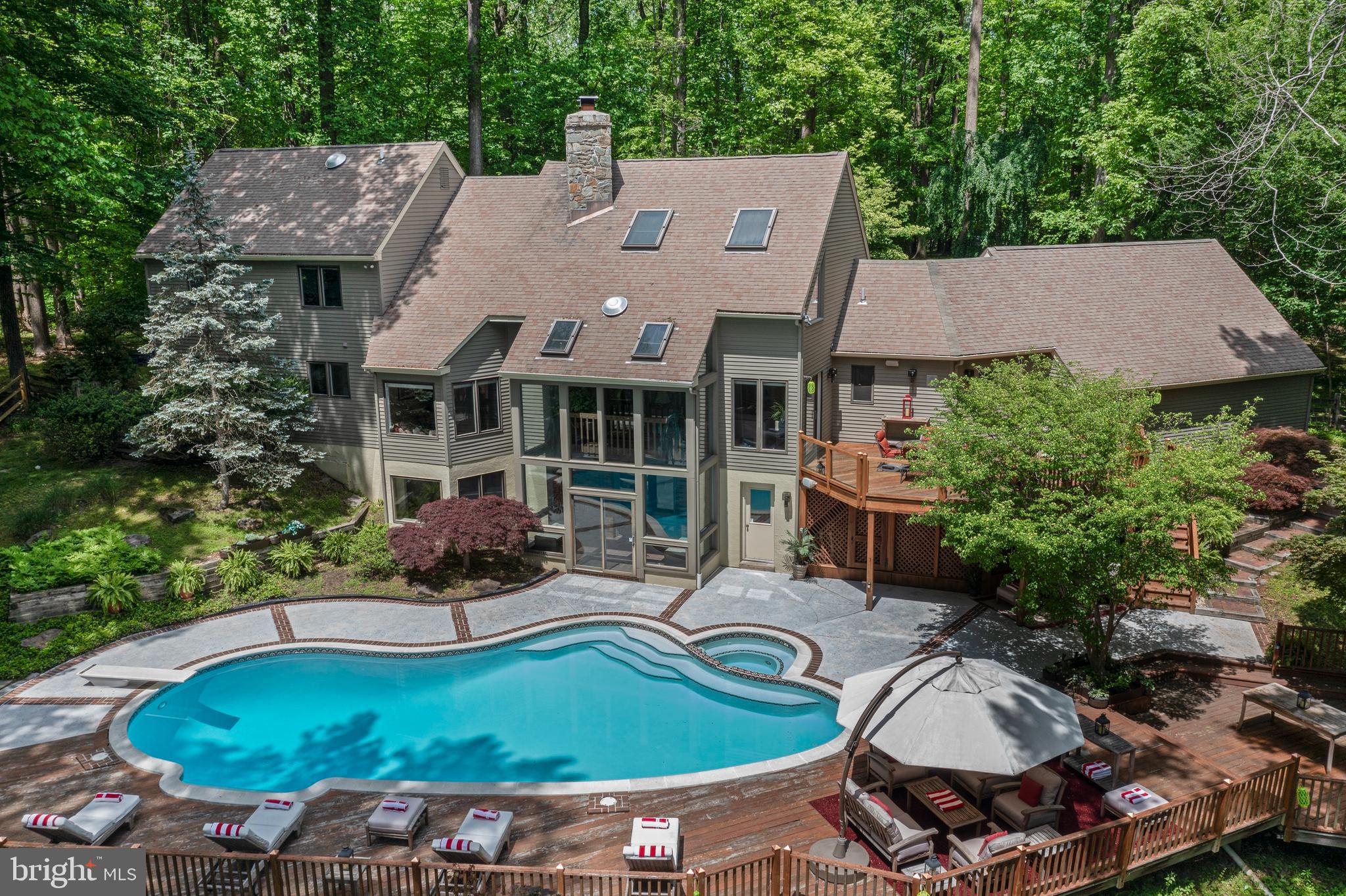 Welcome to this stunning contemporary Cape, perfectly situated on 3.3 private wooded acres at the end of a quiet cul-de-sac in the heart of Chadds Ford.  This beautifully maintained home, with numerous recent upgrades, combines graceful elegance with an open, light-filled floor plan and exceptional landscaping.  A perfect home for entertaining!  Enjoy a peaceful, private setting with serene views from every angle.  The covered front porch opens into a dramatic two-story foyer with immediate sightlines through a wall of windows showcasing the backyard. At the heart of the home is a spectacular two-story stone fireplace with dual fireboxes, warming both the sitting area and the great room. The great room also features soaring cathedral ceilings, a built-in entertainment center, and sliders leading to the main deck and the balcony of the three-story glassed atrium.  A spacious formal dining room is perfectly positioned next to the kitchen and sitting area, ideal for entertaining. The kitchen boasts custom cabinetry, granite countertops, a large bay window over the sink, and a built-in breakfast bar. Off the kitchen, the rear entry provides a walk-in pantry, laundry area, half bath, and access to the oversized two-car garage.  The main level also features a private primary suite with a walk-in closet, a luxurious bath with a steam shower, and sliders to a private deck. A second bedroom on the main floor—currently used as an office—offers flexibility for a nursery or guest room, complemented by a full bath.  Up the open staircase, you'll find a large loft area with four closets, including three cedar-lined closets, perfect for extra storage. This level also offers three generously sized bedrooms and another full bath.  The finished lower level is designed for relaxation and entertainment, featuring a sitting area with a brick fireplace, a second family room, and a flexible space perfect for an office or guest bedroom with an adjoining full bath. Sliders open to the three-story atrium, leading directly to a gorgeous in-ground pool with a built-in spa. Expansive deck and patio areas create a resort-like setting for family fun and entertaining.  This home is accessed by a "Private Drive" that dead ends in one of two cul-de-sacs that services 3 homes of a heavily forested private 10 home enclave.   Located within the award-winning Unionville-Chadds Ford School District, this exceptional home offers easy access to major highways and a convenient commute to West Chester, Wilmington, Philadelphia, and Philadelphia International Airport.  Don’t miss this rare opportunity to own a one-of-a-kind retreat in a truly special setting!