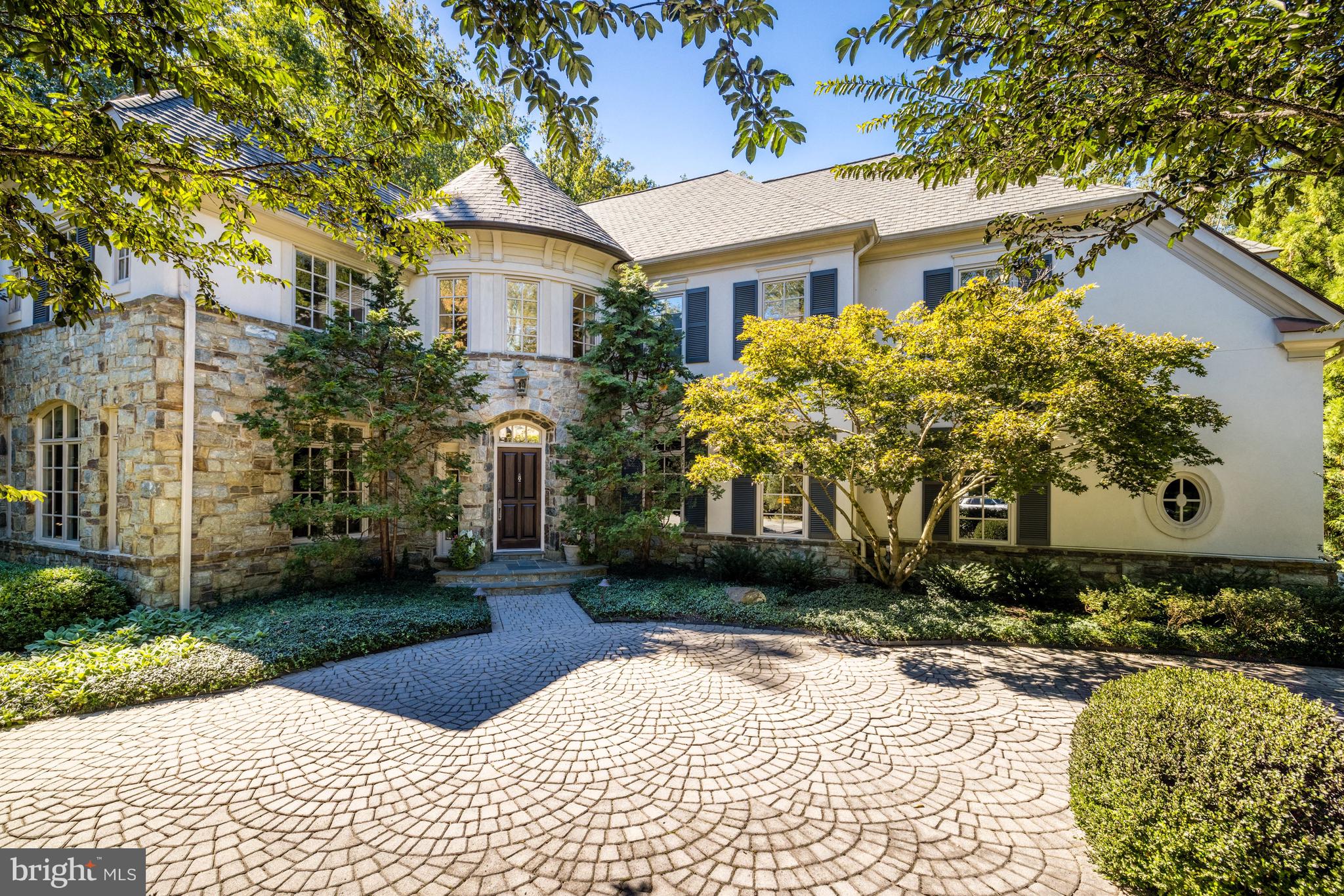 Amidst the stately elegance of McLean’s highly sought-after Woodlea Mill neighborhood, this European Old-World style home is situated on one of the most private and stunning lots in the neighborhood, flanked by approximately five acres of picturesque, HOA-maintained preserved green space. This exceptional home, immaculately maintained by the original owners, features award-winning mature landscaping, including a resort-like heated pool, spa and covered stone patio with outdoor bar, designed and constructed by renowned firm Surrounds Landscape, as well as an elegant paver driveway and 3 car garage.

Abundant natural light coupled with high ceilings and custom architectural details elevate this gracious 5-bedroom, approximately 6657SF residence into a class of its own. An inviting grand foyer with a curved staircase welcomes guests into a formal living room with a beautiful marble surround fireplace imported from France, a spacious formal dining room, and an intimate, cherry paneled library with built-in shelving.

 The lovely French country-inspired kitchen opens to the rear deck with a built-in grill and provides wonderful views of the private grounds. The kitchen’s breakfast area overlooks the adjacent two-story great room, featuring beautiful custom trim around the floor to ceiling windows, a handsome stone fireplace with antique mantel, additional deck access, and a lovely back staircase. A formal powder room, large laundry and mudroom, and access to the 3-car garage with custom commercial-grade Gladiator Garage flooring tiles and organizational system.

 Dual staircases access the upper floor, and the primary suite is its own retreat with a soaring tray ceiling, sumptuous master bath (updated in 2015) and thoughtfully designed, expansive walk-in closet with two full wall mirrors and natural light. Secondary bedrooms all offer either en-suite or a jack-and jill bath.

 The walk-out lower-level features additional views of the stunning and well-manicured grounds, and includes a 700-bottle wine cellar, game room and large bar. The roof, AC units, and hot water heater have all been replaced between 2014-2018.

 The exterior provides a restful setting on .62 acres with 32’ pool with automatic cover, heated spa, covered stone patio with bar, sink and refrigerator, fountain, 20-zone irrigation and professional landscaping.

 The prominent McLean neighborhood of Woodlea Mill is ideally located minutes from the urban hub of Tysons Corner, 20 minutes to Dulles Airport, with proximity to excellent dining and hiking trails. Amid the lush trees and stately landscape, this elegant residence provides a wonderful and classic retreat rarely found in such an accessible location.