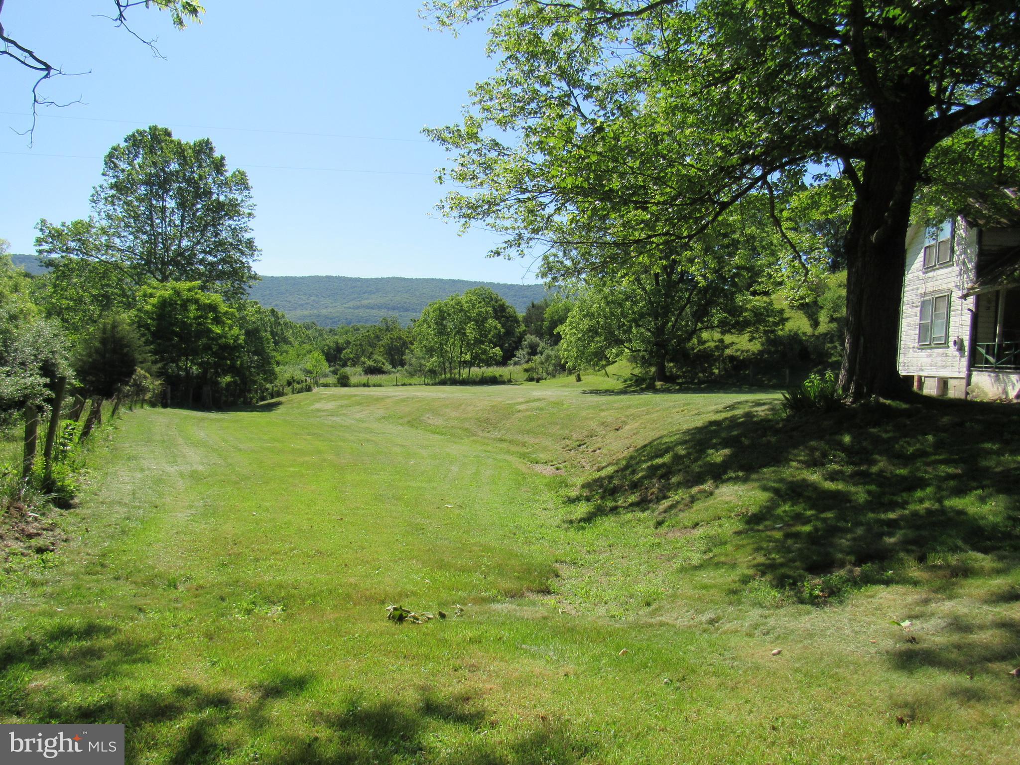 Tranquil and charming 6.5 acres with a small stream that adds to it's tranquility.  Land is on a  paved road just a few miles from Lost River StatePark, Kimsey's Run Dam and Trout Pond Recreation Area.  This would be the perfect place to build your new home with lots of room left over for a big garden.  There is a 1924 farmhouse on the property that hasn't been occupied for 40 years and is sold strictly "AS IS"  House does not have well or septic.   Please be aware that there is a nest of honeybees inside the kitchen walls and the bees are entering right above the door on the side porch.  Please keep gates shut so cows don't get out.