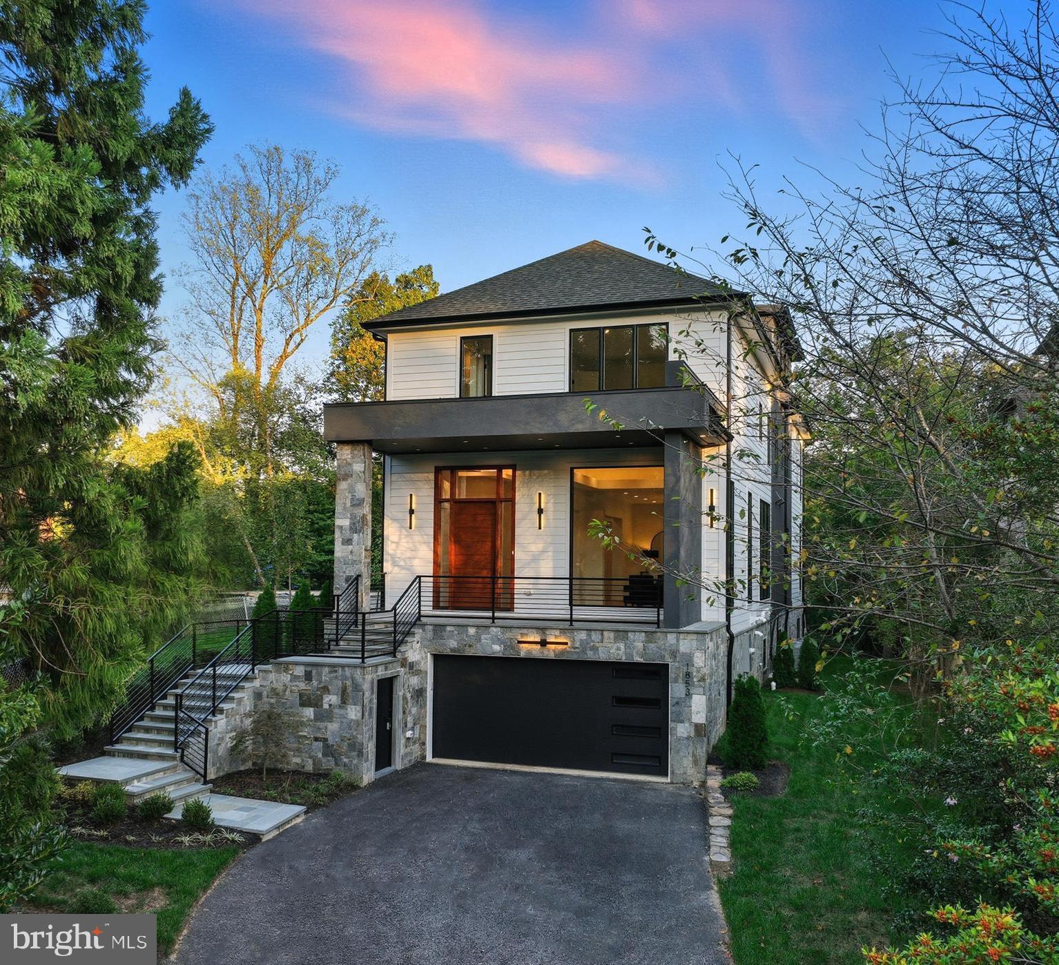 A must see exceptional new construction opportunity in Franklin Park—one of McLean’s most coveted neighborhoods—this elevator-equipped residence offers move-in-ready luxury and unsurpassed quality at an extraordinary value for new construction in the community. Thoughtfully staged and carefully designed, the home reflects a refined approach to modern living where architectural scale, craftsmanship, and everyday functionality come together across four finished levels.
Custom built by Unitec Homes and set on a flat quarter-acre lot, the residence includes 5 bedrooms, 5 full baths, and 2 half baths, all connected by a private elevator. Oversized Pella windows introduce abundant natural light throughout the home, highlighting  sand-in-place wide-plank oak flooring that extends across every level. Volume ceilings, custom millwork, and layered cove lighting create a sense of architectural depth while maintaining a warm and welcoming atmosphere.
Designed for both entertaining and everyday comfort, the main level offers a balanced arrangement of formal and casual spaces. Elegant living and dining rooms introduce the home with graceful scale, while the kitchen serves as its natural gathering point. Custom cabinetry, quartz countertops, and a full suite of Thermador appliances are complemented by generous island seating and a bright breakfast area. Just beyond, the family room is anchored by a striking stone fireplace and framed by expansive windows overlooking the landscaped backyard. Doors open directly to a spacious deck, creating a seamless extension of the interior living space for outdoor dining and gatherings.
Upstairs, the second level centers around a serene primary suite designed as a private retreat. Dramatic windows and elevated ceilings enhance the sense of openness, while the spa-inspired bath features custom built walnut vanities, a soaking tub, and an oversized shower. A fully customized walk-in closet offers boutique-level organization. Additional bedrooms on the level each include en-suite baths and walk-in closets, providing comfort and privacy for family and guests.
Above it all, the fourth level offers a quiet lounge and an additional bedroom with a private bath—an ideal setting for a home office, guest suite, or flexible living space.
Recreation and entertainment continue on the walk-out lower level, where a spacious recreation room with fireplace and bar is joined by another en-suite bedroom and powder room. Large doors open to a patio and landscaped backyard, extending the home’s living spaces outdoors and creating an inviting setting for gatherings or quiet relaxation.
Exterior details are equally refined, with sleek black windows, stone accents, and an inviting covered front porch that compliments the surrounding Franklin Park setting.
Conveniently located ½ mile from the newly renovated Chesterbrook Shopping Center, and a short drive to Chesterbrook Swim & Tennis Club.  Located in the  highly sought-after Chesterbrook Elementary, Longfellow Middle, and McLean High School pyramid.
A rare opportunity to own a newly built, elevator-equipped residence in one of McLean’s most established neighborhoods—where thoughtful design, enduring materials, and exceptional value meet.