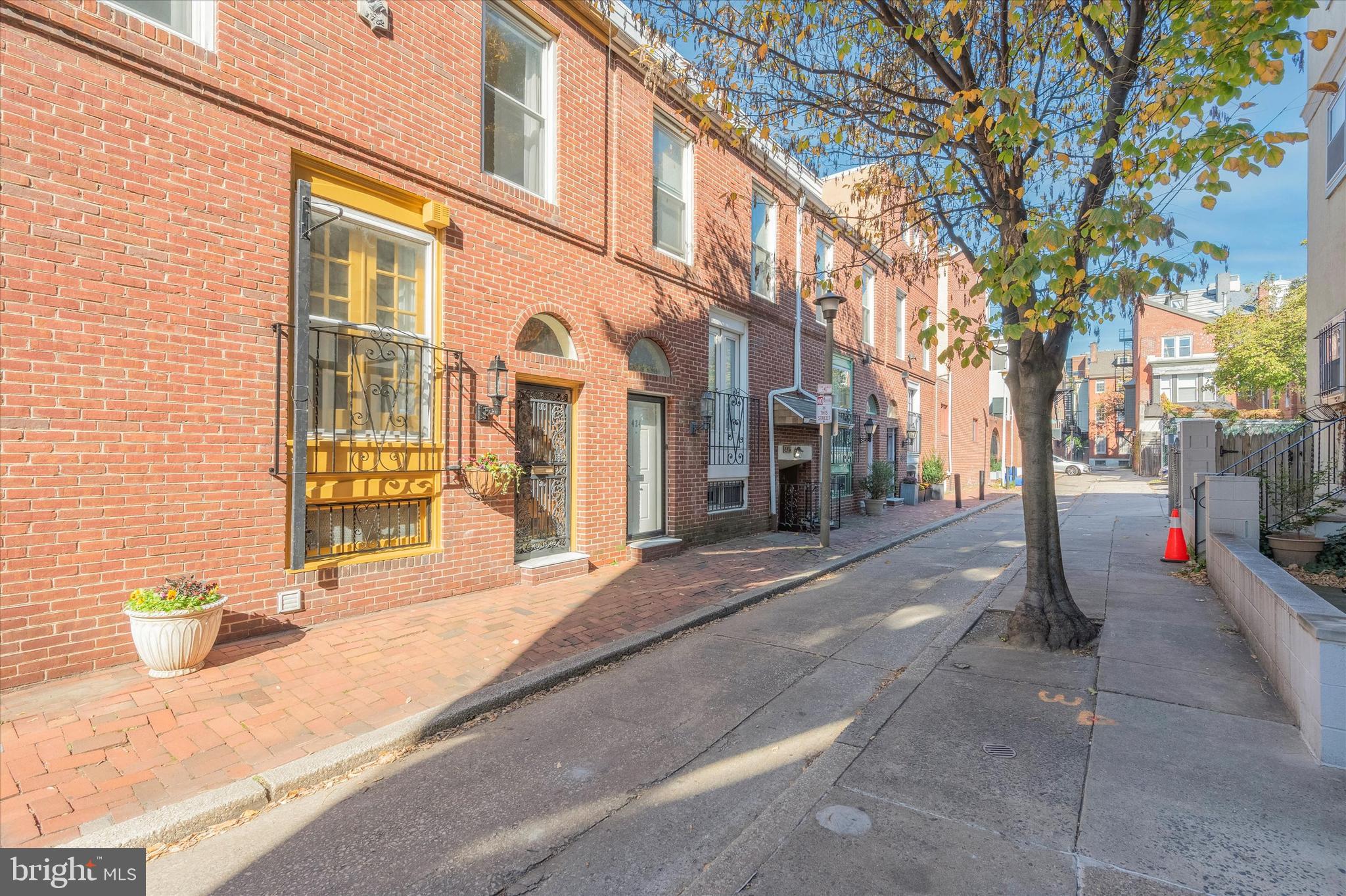 Philadelphia Traditional meets Sexy 70's Design Chic in this fabulous 4+ level Townhome in Washington Square West. Don't be fooled by the charming red brick sidewalks, a handsome black lantern to light the way, and authentic Colonial colors of yesteryear gracing the cozy front entrance and suggesting the early days of our Fair City...Just step inside and the sophisticated glamour of the "more-is-more" era when this Home was built (1977c.)- and you'll find that flawless interior architecture swings refreshingly to Today's exacting standards! A freshly painted, dramatically carpeted Hall of epic heights greets; and a beyond-measure circular floating, dark paneled staircase arises as an enticing focal point, further inviting one to want what's offered beyond...Cleverly structured to maximalize every precious square foot, split levels serve like an M.C. Escher painting throughout: with delightful discoveries awaiting on each Landing.  Beautiful and impeccable honey-hued old-growth Oak floors wind and wend throughout the Home, effortlessly uniting each warm space. A generously sized Living Room with its subtle wood-burning fireplace, opens to a sliding glass wall with a recently re-built Balcony deck. The stunning view overlooking your very own, Oh-so-private, preciously landscaped Courtyard- delights the spirit. On ground level, an indoor/outdoor dining and cooking experience beckons, with culinary creativity allowed to blossom- and fantastic entertaining spaces its reward. Brand-new stainless Appliances have just been added for move-in-ready Holiday frolic. The top levels offer not only glorious light, continued privacy, as well as spectacular City line views...but 2 additional Full Bathrooms to serve the delicious rooms. Each space has tremendous character: another full bank of architectural windows, as well as a loft-like jewel crowning the home- to be used perhaps as a wonderful Bedroom with ample closets- or an inspiring Studio space... Walk the area's A+ rated tree-lined streets to Wholefoods, the vibrant Center City restaurant scene, museums, nearby parks, and tennis courts...then come home to a glorious quality of life right beyond your welcoming frontdoor...