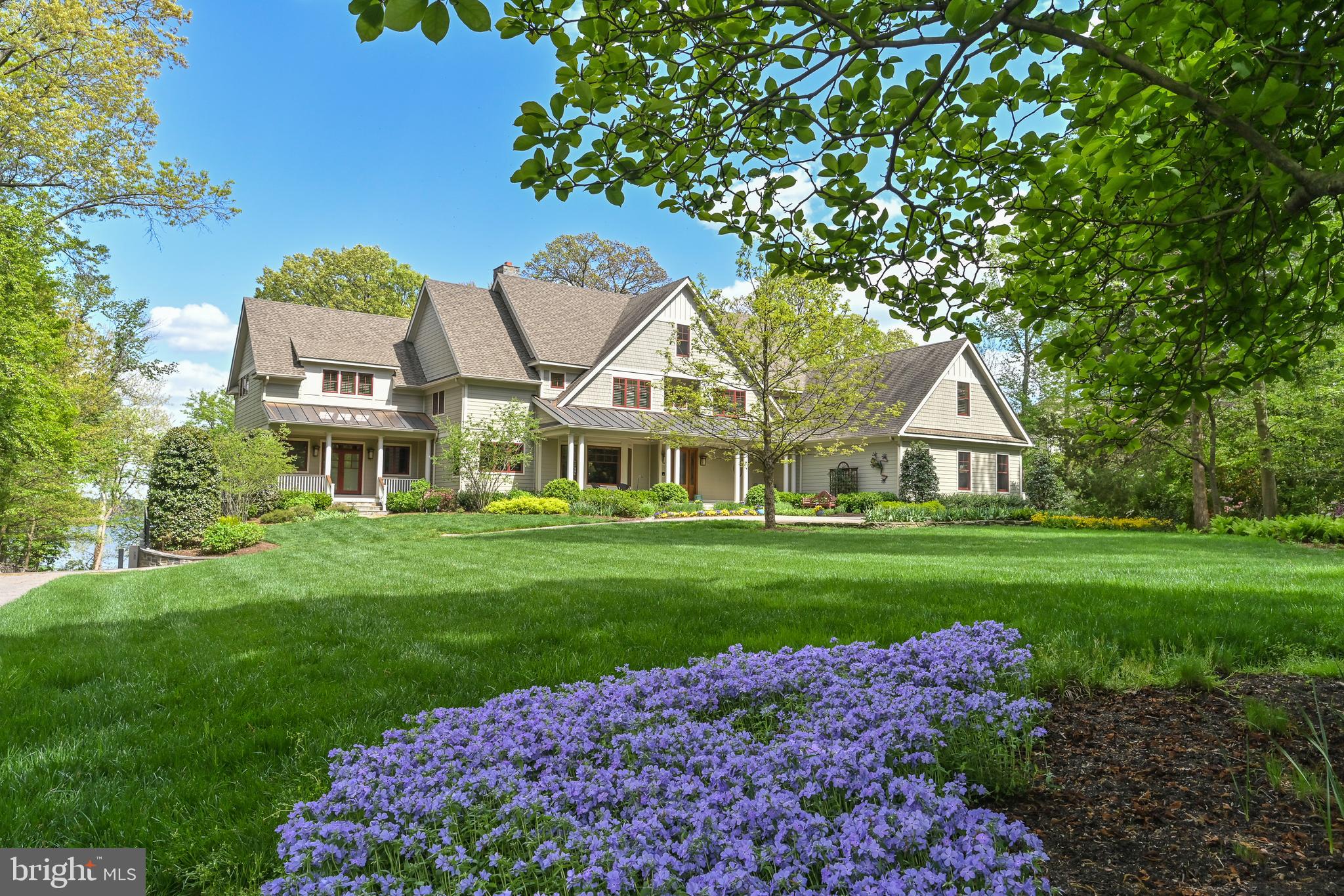 A Waterfront Masterpiece on The Potomac River, just 35 minutes from Washington, D.C., awaits in the enclave of Mason Neck—a sanctuary in Northern Virginia. Known for its expansive regional & state parks, pristine nature & wildlife reserves, equestrian facilities, and golf course, this area offers an unparalleled lifestyle of sophistication and serenity. Historically significant, the land was once the home of George Mason, a Founding Father and author of the Virginia Declaration of Rights, adding a rich cultural heritage to its allure. This distinguished estate boasts over 225 feet of breathtaking waterfrontage where you can drive down to a 269-foot private dock (no stairs), epitomizing an exclusive water-centric lifestyle. As you traverse the gated circular entry and immaculate grounds with beautiful native & ornamental plantings, you are greeted by the stately front motor court. Designed by the visionary architect Tom Flach and constructed by the renowned KohlMark Group, this craftsman-style residence showcases exquisite bespoke finishes throughout. Enter through an artisan-carved stained glass door into the grand foyer, where a majestic barrel vault ceiling with cedar wood inlay and elegant cove lighting adorns the travertine center hall. Panoramic water views grace every space on the main level. The formal living room features a coffered ceiling, an opulent marble-surround wood-burning fireplace, and custom built-ins. The adjacent formal dining room, also with a coffered ceiling and intricate crown moldings, opens to luxurious outdoor entertaining spaces with breathtaking river views. The gourmet kitchen, clad with richly painted cherry cabinetry, lustrous quartzite countertops, and an expansive island, boasts professional-grade stainless steel appliances. A rear pantry with commercial-grade appliances, a main level laundry, and rear staircase complement the kitchen. The breakfast area opens to the hearth/ family room, featuring a striking cedar cathedral ceiling, a grand stone fireplace, custom built-ins, and sweeping water views. In the left wing, an octagonal library opens to the rear patio. An elegant office or optional bedroom with a full bath and walk-in closet, along with a refined study featuring a wet bar, opens to a private screened-in porch. Ascend the staircase, adorned with a stunning blue heron stained glass window, or take the private elevator to the upper level. Double solid wood doors open to the sophisticated primary suite sitting room with a marble gas fireplace and captivating water views. The primary bedroom features another stunning cedar cathedral ceiling and a bowed bay window. The spa primary bath, with split vanities, luxurious marble finishes, and an oversized shower, has a second entry from the wardrobe hall lined with built-ins leading to two expansive walk-in closets. The upper front hall, with custom built-in benches, leads to secondary bedrooms, each with en-suite baths showcasing designer finishes. Beyond the upper-level laundry room and powder room lies an engaging game room or optional fifth bedroom. On upper level 2, a fully unfinished space offers boundless potential for future expansion. The lower level features an expansive exercise room, full bath, and a walk-out level recreation room. With over 2,300 square feet of unfinished space, there is ample opportunity for additional customization. The meticulously landscaped rear grounds include a grand stone patio, ambient landscape lighting, an inviting fire pit, and commanding views of the majestic Potomac River. The community features a waterfront park with a beach, pavilion, boat launch, tennis, volleyball, and basketball. This exquisite location is near Old Town Alexandria, Fort Belvoir, & VRE Station, and has easy access to I-95 enhancing this retreat's appeal. This haven is a paradise for nature enthusiasts & boating aficionados alike, embodying unparalleled sophistication, elegance, & refined living—a true waterfront masterpiece.