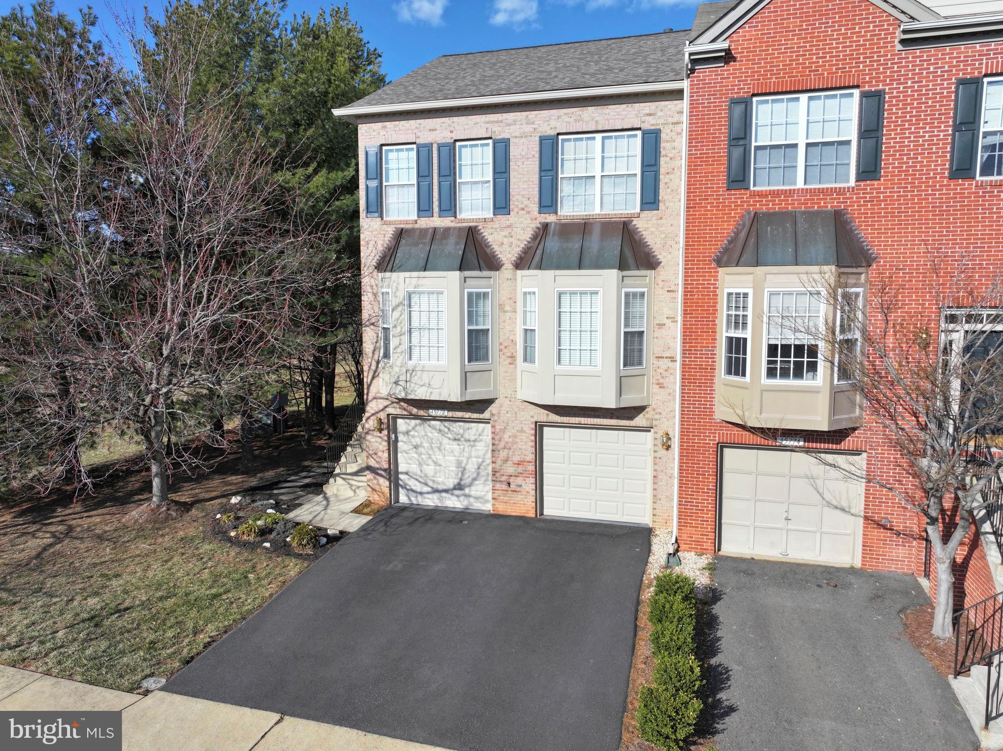 Fantastic 2 car garage end unit townhome in Dulles Towncenter area! This home was built in 2000, and offers 3 spacious bedrooms and 3.5 baths.  There's a 3 level rear bump-out extension, making this gorgeous home extra roomy!  You'll love all the wonderful upgrades, such as hardwood floors on the entire main level, a gas fireplace in the recreation room, and beautifully remodeled kitchen and bath rooms.  The outdoor space includes a deck off the main level plus a patio (with outdoor TV!) on the lower level.  Walk through this home right now by clicking the Tours button to access the 3D Matterport tour! Recent updates include: carpet (2025), roof (2023), new driveway (2023), remodeled master bath, hall bath, and powder room (2019), gas water heater (2022), gas furnace (2020), air conditioner (2020),  remodeled kitchen, remodeled butlers pantry. OPEN SUNDAY from 1 to 3 pm.  It's time to make your move!