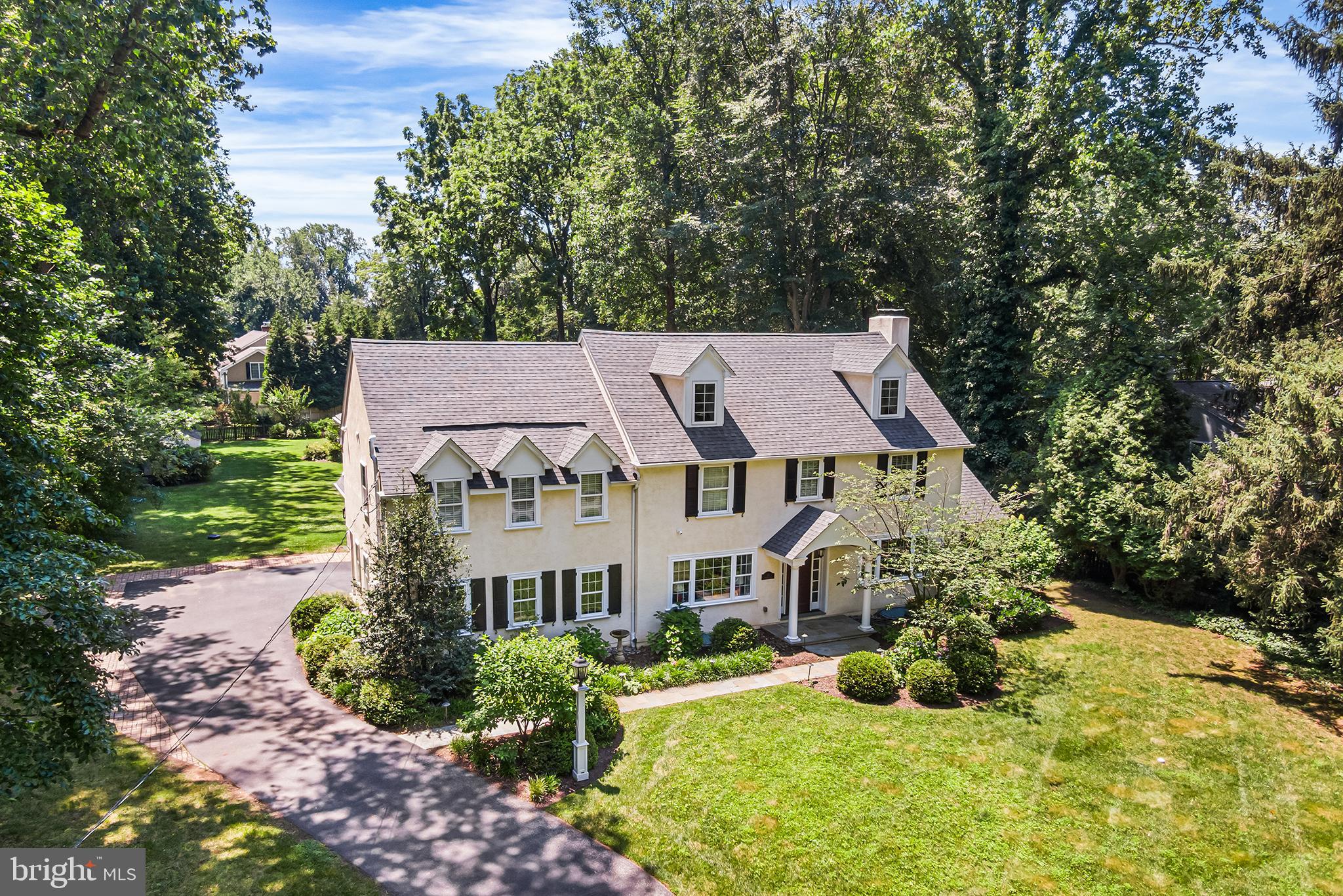 Located on a picturesque tree-lined street in one of the Main Line’s most desirable neighborhoods, this stunning Colonial offers the perfect blend of timeless charm and modern comfort. Featuring 5 bedrooms, 3 full and 2 half bathrooms, and a beautifully landscaped, flat rear yard oasis, this home is a rare opportunity in a highly walkable area just minutes from top-rated schools, train access, shopping, and dining. Step through the front portico and into a thoughtfully upgraded interior with gleaming hardwood floors, elegant millwork, and abundant natural light. The main level boasts a spacious formal dining room with French doors that open to the rear yard and access to a bright sunroom with tile flooring that offers year-round enjoyment.  The expansive gourmet kitchen is a chef’s dream with granite counters, a large center island, breakfast area, stainless steel fridge, wet bar, and gas cooking. The adjacent family room features a slate surround gas fireplace and custom built-in cabinetry. A private office/study with glass doors and deep windowsills, powder room, and mudroom with access to the 2-car garage complete the first floor.
Upstairs, you'll find hardwood flooring throughout, charming window nooks, and a luxurious primary suite with vaulted ceiling, two walk-in closets, and a spa-like bath with double marble vanity, seamless glass shower, and soaking tub. Bedroom 2 features an ensuite bathroom, while bedrooms 3, 4 and 5 share a full large hall bathroom. A second-floor laundry room with sink and storage adds convenience. The walk-up third-floor attic is fully floored and ideal for storage.  The finished lower level includes a second half bathroom, a large recreation/media room, gym, and additional storage with walk-out access to the side yard. Outside, the private backyard retreat features a flagstone patio, perennial gardens, and mature landscaping—perfect for entertaining.
Additional highlights include: First-time on the open market in over 50+ years, completely rebuilt approximately 15 years ago, backup gas generator for peace of mind. This move-in-ready home offers character, quality craftsmanship, and a location that’s second to none. Don’t miss the opportunity to own a truly special property on the Main Line.