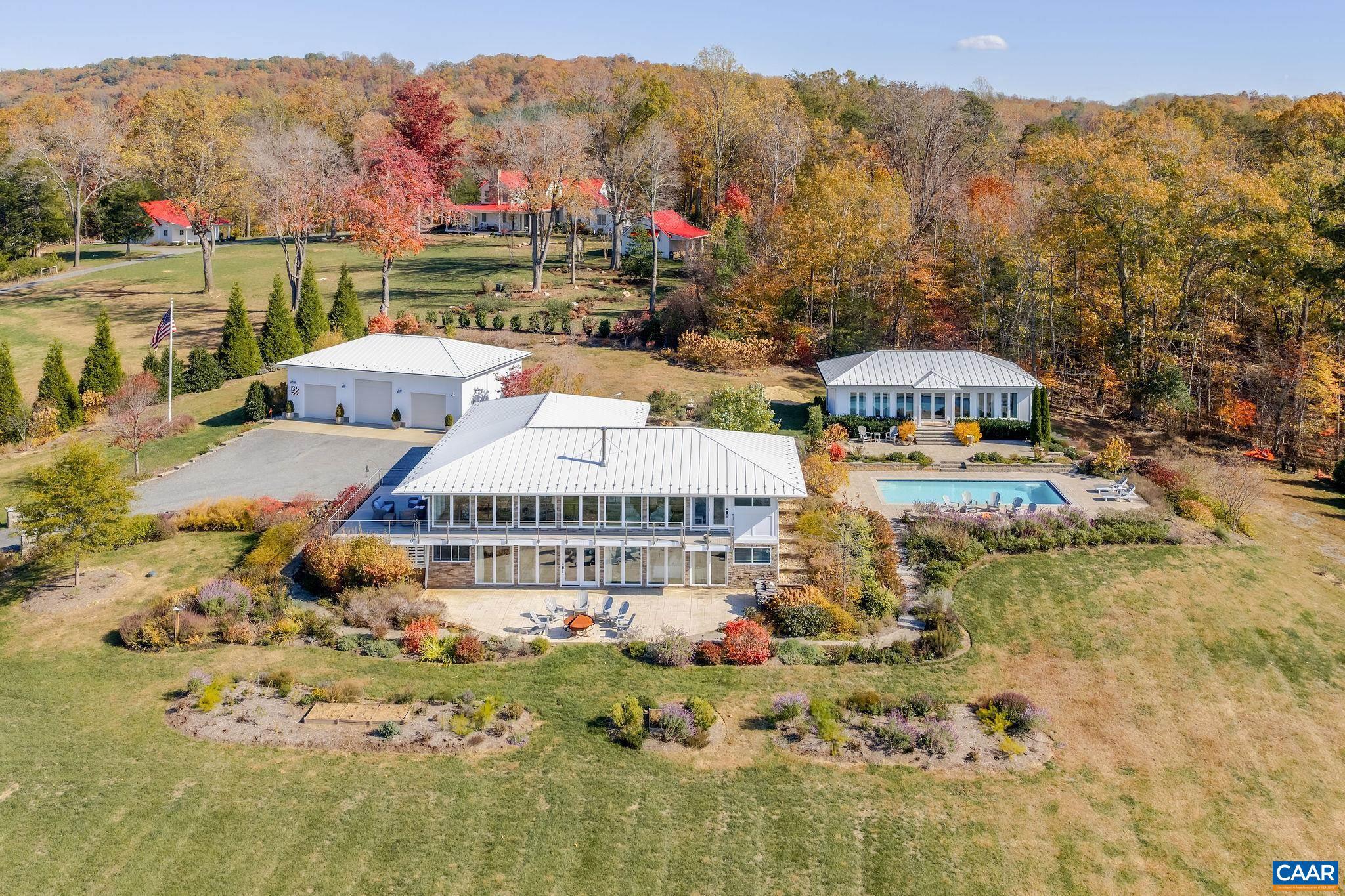 Experience luxurious country living with this stunning contemporary estate in Madison, offering panoramic views of the Blue Ridge Mountains and frontage along the Rapidan River. Set on 24 beautifully landscaped acres, this property combines modern comfort with natural beauty. In 2021, a charming two-bedroom, one bath guest house and heated salt water pool with fire pit were added, creating the perfect retreat for entertaining or relaxing. The main residence was completely renovated in 2022, featuring a gourmet kitchen with Wolf range gas oven and a cozy seating area and fireplace, a main-level primary suite, and breathtaking views from every room. Enjoy manicured year-round gardens that ensure something is always in bloom, and a three-car garage with space for large vehicles. This remarkable property offers a rare opportunity to enjoy refined living surrounded by the tranquil beauty of Virginia?s countryside.,Granite Counter,Maple Cabinets,Painted Cabinets,White Cabinets,Wood Cabinets,Fireplace in Den,Fireplace in Kitchen