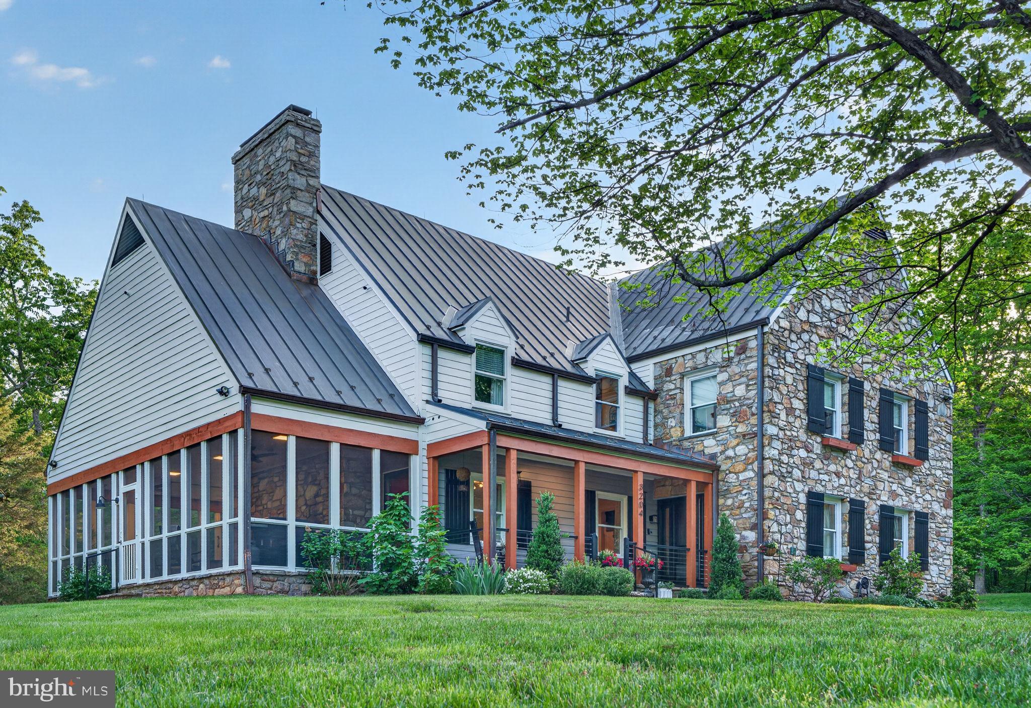 Rarely does a property of such quiet distinction come to market. Spanning more than 36 acres across three combined lots and backing to protected land, this remarkable estate offers a rare sense of seclusion—just minutes from the heart of Haymarket. For those seeking versatility or development opportunities, Prince William County has already reportedly granted preliminary approval* for additional building rights and potential family subdivision across the three lots. *Buyers are encouraged to independently verify all details related to development rights, subdivision potential, and easement terms.

The five-bedroom farmhouse is a thoughtful blend of historic charm and modern refinement. Sunlight fills the interiors, where exposed wood beams add warmth and character. The chef’s kitchen, appointed with soapstone countertops and a professional-grade gas range, is equally suited for intimate gatherings or larger-scale entertaining. A stunning wraparound porch—partially enclosed and anchored by a fireplace—extends the living space outdoors, overlooking sweeping lawns, mature trees, and a serene pool and spa set against the backdrop of the Bull Run Mountains.

Every detail has been carefully considered. Recent enhancements include wide-plank flooring throughout, a reimagined primary suite, updated secondary baths, and a refined laundry and mudroom. Significant exterior and systems upgrades include a new copper roof, gutters and downspouts, cedar siding, a paved driveway, hand-laid stone walls, a new gas furnace, hot water heater, and a comprehensive security system. The three-car garage, complete with a dedicated workshop, offers exceptional utility for collectors or hobbyists.

A private office suite—with its own full bath, secure access, and high-speed connectivity—provides an ideal setting for remote work or creative pursuits. With a separate rear stairway, it also offers flexibility as an au pair or in-law suite.

The grounds are equally extraordinary. Private walking trails wind through wooded areas rich with wildlife, while a spring-fed pond reflects the changing seasons. A charming working homestead, complete with duck and chicken coops, adds to the property’s authentic country appeal. Multiple terraces, both covered and open-air, along with fireside gathering spaces and expansive lawn areas, create an ideal setting for year-round enjoyment.

This is more than a home—it is a legacy property defined by land, light, and enduring beauty. A portion of the property is also protected by a conservation easement, preserving its natural character for generations to come. For those who value privacy, scale, and timeless setting, this is a truly rare offering.