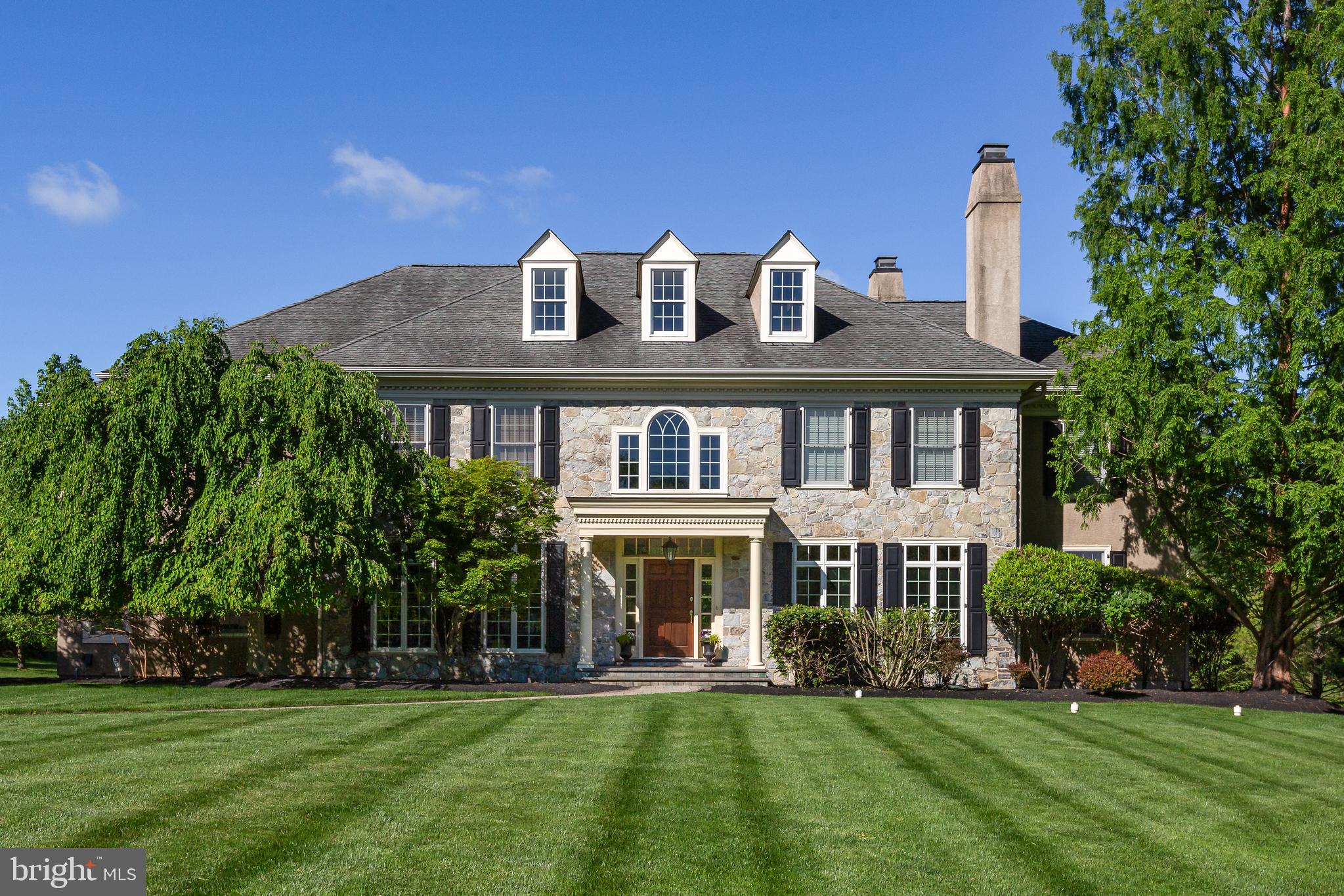 Stately in stature and brimming with timeless curb appeal, welcome to 211 Twinings Lane in the sought-after Whitegate community of Wayne! Built by the esteemed Bentley Homes, this home is truly everything you’ve been looking for: a move-in ready center hall colonial set on a quiet cul-de-sac in a coveted Main Line location. Timeless details include the sweeping front lawn, the foyer’s grand staircase, the two-story stone fireplace, archways separating the rooms, red oak hardwood flooring, and soaring ceilings. Modern convenience hasn’t been forgotten, though, with a spacious, chef-inspired open kitchen with a large center island and custom-built cabinetry, built-in shelving, a three-car attached garage, and many custom upgrades throughout the home. Find all this and more in your dream home: 211 Twinings Lane!  

Upon entering, you immediately take in the home’s dignified atmosphere: with a grand staircase flanked by two arched doorways– each with beautiful casework– leading to the living and formal dining rooms. A center hall colonial, the home embodies excellent front-to-back flow, making it an ideal layout for seamless hosting. The two-story great room features soaring windows and hearth-to-ceiling stone fireplace. A sunroom with a tile floor is located off the great room: a cozy room to relax and enjoy the natural light pouring in from the many windows. The study with built-in cherry wood bookshelves, doors, and windows offers a quiet space for working from home or reading a book. 

The open and spacious gourmet kitchen is a few steps from the great room. The oversized granite-topped island and abundant custom cabinetry are a few of the many upgrades that create this chef-style kitchen. Upgraded appliances include a warming drawer and wine cooler as well as a newly installed touch faucet for added convenience. A classic breakfast room with three sides of windows and access to the spacious patio allows for informal dining indoors or out. A large mudroom, including built-in storage and one of two main level powder rooms, leads one from the attached garage into the kitchen. A second powder room centrally located for guests’ use completes the main level. 

The second floor, accessed by the front or back stairs, boasts a wide hall open to the soaring windows of the great room. There are five bedrooms and 3 baths on this level. Entry to the primary suite is through French doors and a vestibule. The primary suite includes a spacious bedroom, a flexible space which can be used as a sitting room or dressing room with two large, custom closets and an en suite bathroom. The primary bath includes a soaking tub, walk-in shower, and a long vanity with dual his-and-her sinks. An open hall leads to 4 large bedrooms with custom closets and attached baths. A laundry room with counter space and a window allowing natural light completes the second floor. Head upstairs once again to find a partially finished space on the third level with endless possibilities for your customization. 

Upgrades added to this home during construction include sound insulation of the primary suite, house alarm system, lawn sprinkler system, gas fireplace, gas line to patio, full unfinished basement with French door access to outdoor concrete stairs to grade, upgraded cabinetry, woodwork, and hardware throughout. The coveted Whitegate community has a playground and tennis courts for residents' enjoyment, and the Wayne location is convenient to all the Main Line has to offer!
