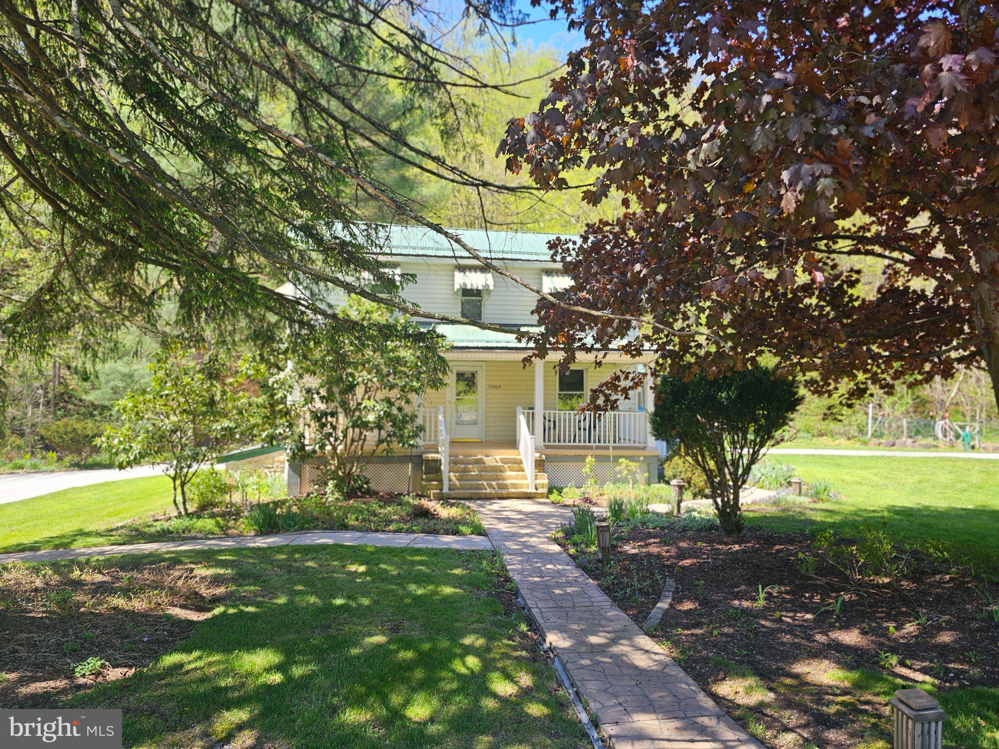 OFFER DEADLINE 4/30/202 @ 6:00 P.M.   Nestled on over an acre of serene land, this charming 1903 detached home offers a perfect blend of classic character and modern comfort. The main floor laundry adds convenience to your daily routine, while the spacious layout ensures a cozy atmosphere throughout. With two comfortable bedrooms and two full bathrooms, this residence is designed for both relaxation and functionality. Outside, the extensive hardscape creates a welcoming outdoor space, perfect for entertaining or enjoying quiet moments. Every where you turn there are flower beds each with its own watering hose to make it convenient for watering. The screened porch invites you enjoy your morning coffee or to unwind in the evening while overlooking the lush surroundings. Additional structures, including a barn and shed, provide ample storage and potential for hobbies or projects. For those who appreciate nature, the property features a seating area overlooking a tranquil creek, offering a peaceful retreat right in your backyard. The circular concrete driveway enhances accessibility and adds to the home's curb appeal. This property is not just a house; it's a place to create lasting memories. Experience the charm and comfort of this unique home, where every detail has been though