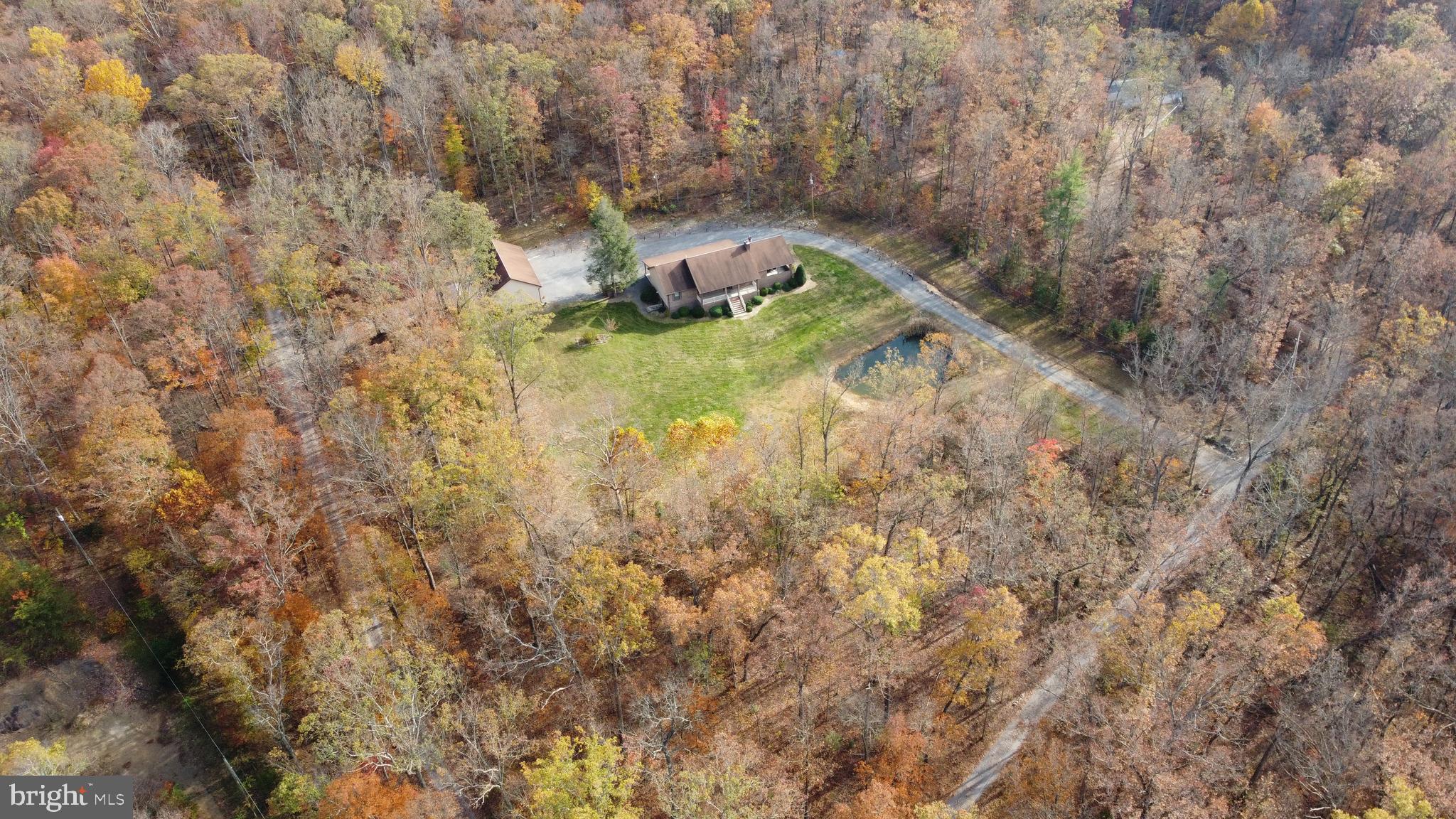 This charming, move-in-ready single-family home epitomizes the ideal residence, featuring a grand front porch overlooking your personal pond with a backdrop of mature trees and pristine mountains. Situate on 6 acres backing the George Washington National Forest, this Ranch style home includes 3 bedrooms with 2 ½ baths on the main level and a loft bedroom, giving you 4 bedrooms to accommodate your family and friends plus a full unfinished walkout basement. The floor plan creates a welcoming family living space that enhances the lifestyle of all occupants. The kitchen with oak cabinets is an invitation for family to gather while the living room welcomes you to enjoy the fireplace with a wood insert and bay window. A sunroom provides additional space to expand. A back porch provides an opportunity for you to enjoy the beautiful views and tranquility of the George Washington National Forest that borders the back yard. An attached 10x30 carport is a plus and the detached 30x50 garage/man cave has two remote controlled garage doors with plenty of space for storage of tools, cars, lawn mowers, boats, fishing gear, and other toys. Big bonus is the finished living area with a ½ bath in the detached garage for perfect man cave. Additional storage space in the utility shed. Located at the end of the road approximately 30 minutes from Winchester, VA and an hour and a half from Washington, DC.