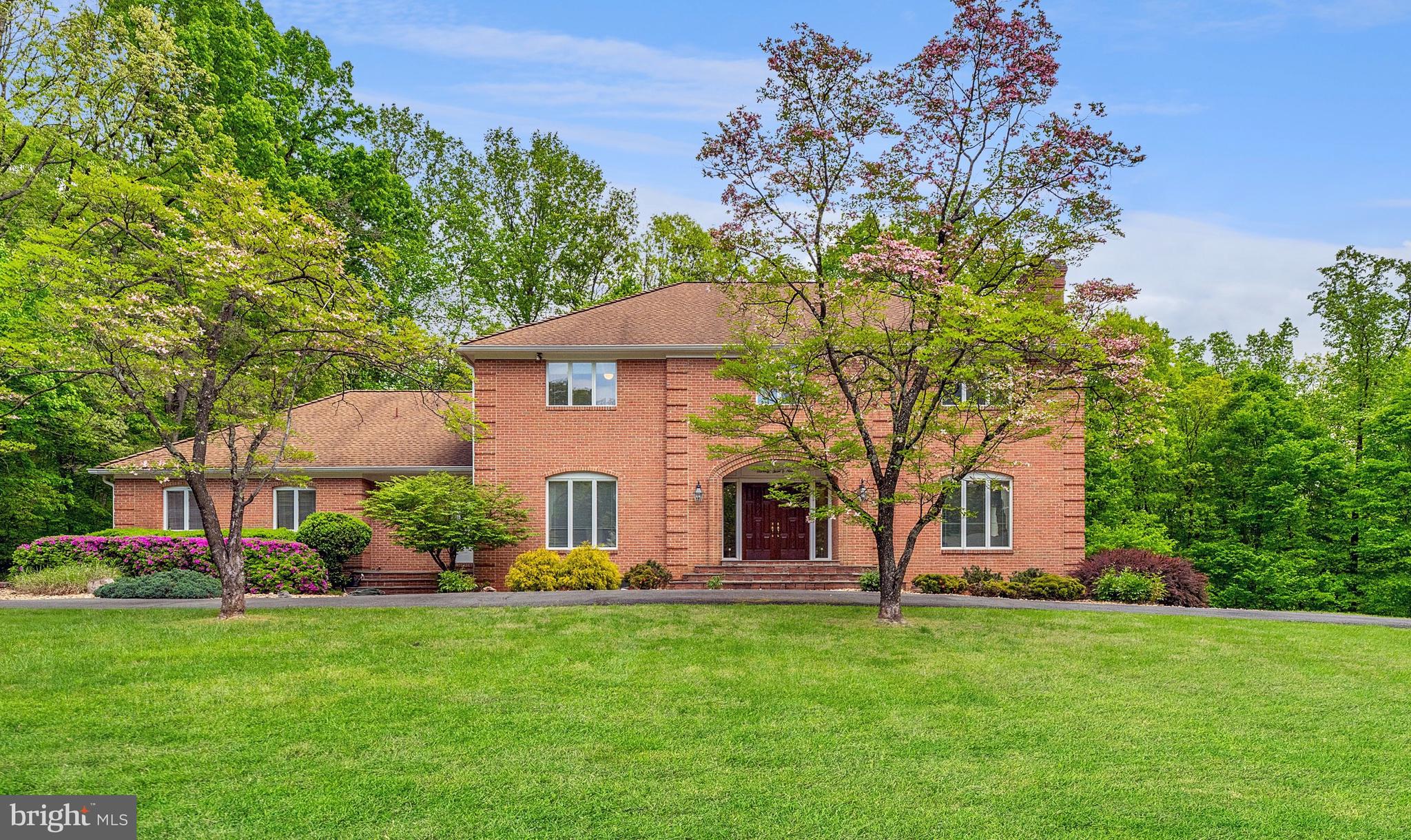 Introducing 7309 Brookstone Court, a custom built brick colonial nestled in the wonderful Mazza Woods neighborhood of Potomac, Maryland. Original owners that carefully worked with their custom builder and architect to construct this perfectly proportioned home.  Boasting a gracious floor plan, this home features four bedrooms, four and a half bathrooms, and 6,900 square feet of thoughtfully architected living space. Positioned over three acres, complete with a circular driveway, three car garage and an inviting outdoor swimming pool, this property is a rare find in the Potomac area.

Step inside through the double doors and be greeted by the two-story foyer, adorned with tile flooring and an elegant chandelier. Descend into the great room, a gathering area complete with a central brick surround wood-burning fireplace. Conveniently adjoining, a wet bar awaits, while beyond the rear doors lies access to a sunroom. With its vaulted ceiling and glass surround, the sunroom seamlessly merges indoor and outdoor spaces, offering views of the surrounding woodlands. The open kitchen beckons, a welcoming space for both cooking and congregating with its eat-in area and countertop bar seating. A stainless steel refrigerator and dishwasher, alongside dual ovens, and a double door pantry, are an added touch for culinary convenience. Display shelving is ideal for showcasing glassware, while ample cabinet space is available to fulfill all your storage needs. Adjacent, a practical mudroom provides easy access to a main level washer and dryer, while a three-car garage comes complete with an EV charger. An at-home office beams with natural light and views of the pool, highlighting the treetops through expansive windows. Entertain in the dining room, wrapped in tasteful dental and chair-rail molding, illuminated by a graceful chandelier. Relax in the living room, where dental molding and a wood-burning fireplace create a warm ambiance. Floor-to-ceiling windows flood the space with sunlight, while hardwood flooring can be found throughout the main level.

Ascend the curved stairwell to the upper level, where you will discover four bedrooms and three full bathrooms. The primary suite is spacious retreat, offering sizable space for both a bed and sitting area. Continue to the closet, equipped with multiple sections to organize your wardrobe and daily essentials. The primary bathroom showcases custom tile work and highlights a newly renovated walk-in shower. Unwind in the oversized tub, while dual vanities provide practicality to your everyday routine. Continuing on this level, you will find two generously sized bedrooms interconnected by a Jack-and-Jill bathroom. An additional bedroom is complete with its own bathroom and dual closets.

Discover boundless opportunities for leisure and entertainment in the lower level of this home, with over 2,000 square feet of space enveloped in tile flooring. At the heart of it all stands a wood-paneled bar, complete with a sink, beverage refrigerator, and integrated shelving. Beside this focal point, custom built cabinetry offers storage solutions. Sliding glass doors provide access to the outdoor pool area, while a recreation space calls for gatherings around game tables. Tucked away in a corner, a cozy sitting area invites casual lounging. Completing this level is a bedroom and bathroom, along with a bonus room and storage closet. The outdoor pool is nestled to the side of the yard and surrounded by patio space, perfect for entertaining or unwinding in the sun. The backyard features a lush grassed area, providing ample space for recreation. A side deck easily accesses the kitchen, enhancing the seamless indoor-outdoor flow.

Mazza Woods is a fantastic neighborhood, ideally positioned near the Potomac Village and Great Falls National Park. Enjoy swift access to I-495 and Clara Barton Parkway, ensuring effortless commuting. Situated within the Walt Whitman School District, this home is a unique find.