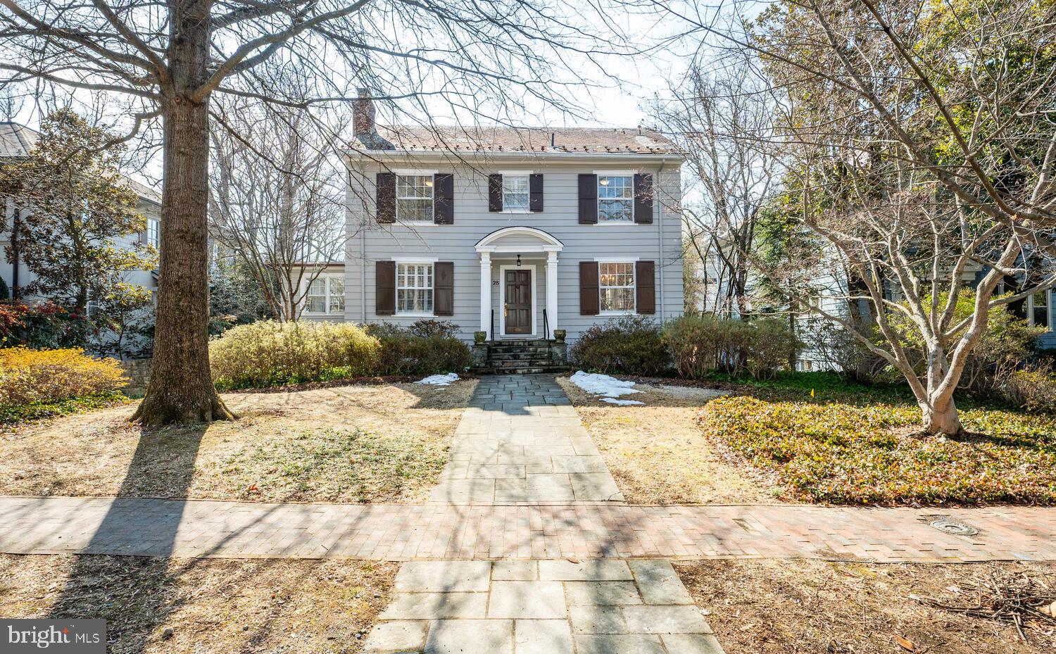 Upon the first moment you step inside this home in Chevy Chase Village, vintage, 1923, it makes you feel warm and happy all over. It is not just the gorgeous furnishings, but the high ceilings, —over 9 feet—, larger than usual windows and the marvelous carved moldings, fireplace mantle and site view of the handsome staircase at the back of the home. 
The covered front porch opens to the formal living room and a peek into the formal dining room to the right. Large windows abound in this home and both rooms enjoy them on two sides. Hardwood floors run throughout the home and are original. Those areas you might want renovated, have been. You will love the recently redone kitchen. Every detail has been thoughtfully chosen with a kitchen expert and the owners who enjoy the kitchen for cooking and casual eating. There are plenty of white cabinets, some with glass fronts, grey quartz countertops, marble backsplash, terrific appliances, white cabinet fronted refrigerator and hardwood floors. A round table was commissioned just for this space. The owners wisely sited the oversized under-mounted sink right where the south facing windows span the back of the kitchen enjoying views of their deep back yard with grass, plentiful perennials and hardscape. A side rear door opens to the deck with benches and table space for many.
Also on this level is a large room that can be a family room, library, study, whatever the need. It also has an abundance of light from windows south and east facing.
The second floor has four bedrooms and two full baths, both of which have been renovated and will appeal to the taste of today’s buyers. One is a hall bath with a tub/shower and the other is a jack-n-jill bath with a walk-in shower.
The third floor has another full bath, more vintage, a bedroom or office as you see fit, and a great cedar closet for extra storage.
Head to the lower level, which is a walkout to the fenced back yard. Here is a recreation room, a kitchenette, a full bath, a bedroom, an office/study, the laundry room and a mechanical room. There is good light from large south facing windows and a French door that leads to a large flagstone patio, grass, hardscape and a one car attached garage.
The slate roof is kept in shape with inspections and replacement of tiles as needed and was recently serviced. The boiler is from 2021 (radiators heat the home silently and with steady heat). The hot water heater is from 2017, and the central air system was renewed in 2021. The owner keeps the home ship shape.
If you are not familiar with Chevy Chase Village, know they have a manager, and several other employees who serve the residents Monday-Friday 8:00am-4:00pm. The Village police force works 24/7 and will check your home, and pick up papers, mail, and packages, if you travel and make the request. The elected board oversees the budget, management and works to make sure residents enjoy the neighborhood. Some volunteers organize gatherings and the Village always has a Halloween party for kids, 4th of July parade and picnic, a Holiday party for young and old as well as other gatherings.  Efforts are made to bring residents together.