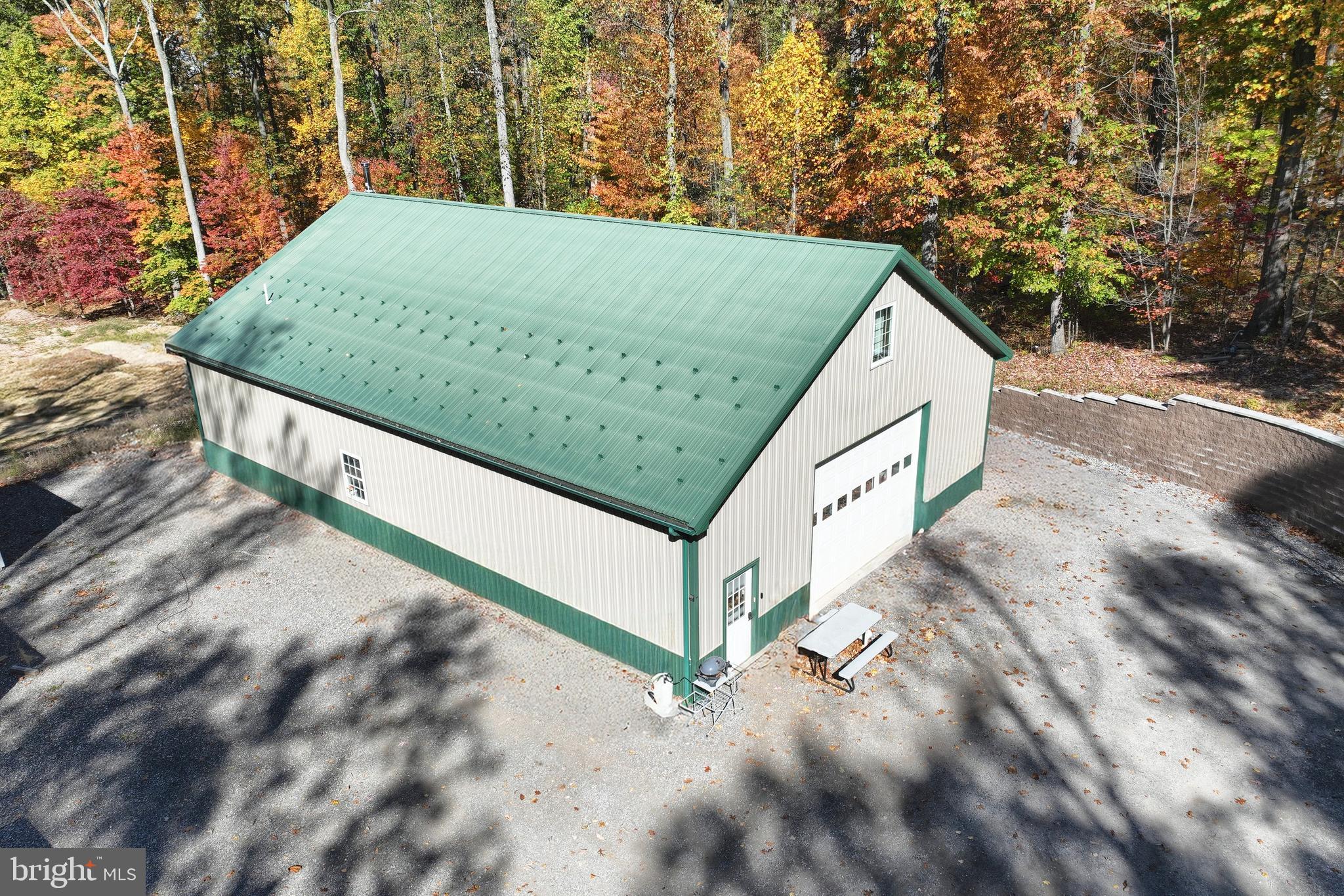 Nestled on 4 serene acres in the picturesque Pigeon Hills of York County, PA, this unique property offers the perfect blend of privacy, convenience, and opportunity. Located just minutes from Codorus State Park and an easy commute to Maryland, this versatile estate features a spacious 2,400 sq. ft. pole building with 1,400 sq. ft. of comfortable living space across two floors. Inside, you'll find a well-appointed 1-bedroom, 1.5-bath layout with family rooms on both levels, creating a warm and inviting atmosphere. The building also boasts 2,000 sq. ft. of garage space, providing ample room for storage, a workshop, or hobbies. With plenty of parking for a boat or camper, this property is ideal for outdoor enthusiasts. Looking to build your dream home? A 2,100 sq. ft. foundation is already in place across the street, ready for your vision to come to life. Don’t miss this rare opportunity to own a one-of-a-kind retreat in a peaceful yet convenient location!
