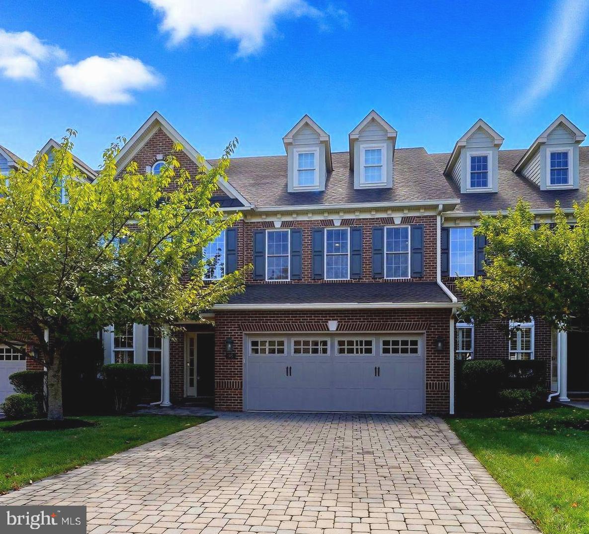 Welcome to this elegant residence in the highly desirable Delancey Court community of Newtown Township. Seamlessly blending sophistication with modern comfort, this home offers a prime location and beautifully designed living spaces throughout. The two-story foyer establishes a grand tone with its circular staircase and stunning, gleaming hardwood floors that flow into an open-concept main level, perfect for both entertaining and everyday living. The gourmet kitchen is a chef’s dream, featuring stainless steel appliances, custom cabinetry, granite countertops, and island seating. A sunlit breakfast area provides a casual dining option, while the formal dining room is perfectly suited for hosting dinner parties and special occasions. The spacious family room, complete with a gas fireplace and soaring ceilings, serves as a warm and inviting gathering space.
In contrast, the formal living room is bathed in natural light, offering charming views of the landscaped surroundings. The expansive primary suite boasts a tray ceiling, ample closet space, and a spa-inspired bath featuring a soaking tub, upgraded tile finishes, and an oversized walk-in shower. Upstairs, two additional bedrooms share a well-appointed full bath. Meanwhile, the generous loft area is furnished with a sofa, chair, reading nook, and entertainment unit, creating a versatile space for relaxation on the second level. The highlight of the third level is a private home theater, designed with stadium seating for the ultimate entertainment experience. Throughout the home, recessed lighting enhances each room, providing both style and functionality. Outdoor living is equally impressive, with lush landscaping, manicured grounds, and a private paver patio that offers tranquil views of the woods—an ideal setting for grilling, dining, or simply enjoying the natural surroundings. This stunning property combines elegance, comfort, and convenience in one of Newtown Township’s most sought-after communities. Living in Delancey Court grants access to a spectacular clubhouse featuring indoor and outdoor pools, a state-of-the-art fitness center, a game room, and more—it’s like enjoying a luxury resort year-round. 55 Plus community.