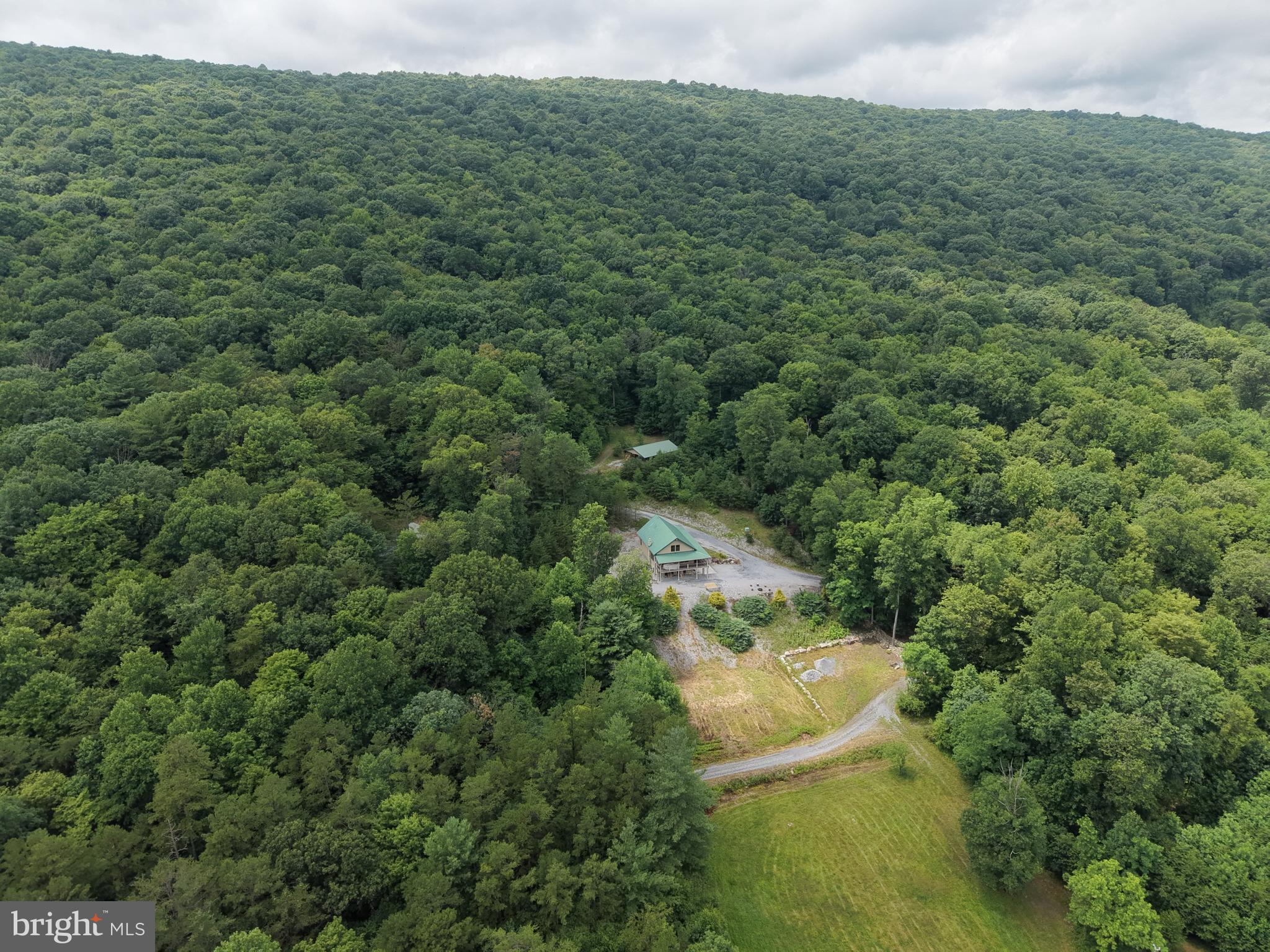 PRIVATE 328+/- ACRE OASIS TUCKED IN THE MOUNTAINS OF HUNTINGDON COUNTY, PA! This property features a modern log cabin, detached garage, equipment building, extensive trail system, and excellent hunting opportunities. The cabin includes 4 bedrooms, 3 full bathrooms, a kitchen, dining area, living room with a stone propane fireplace, loft, and a partially finished basement with a wood stove and walkout entrance. The custom log cabin has been well maintained and includes an extensive water filtration system. High-end vinyl shake siding and a metal roof provide a low-maintenance exterior. The 24x30 detached garage includes a storage loft and offers plenty of room for vehicles, tools, equipment, or recreational toys. An additional equipment building provides even more storage space. The property offers excellent hunting for deer, bear, turkey, and other wildlife. The wildlife displayed in the cabin are animals that were harvested on the property. Miles of groomed trails provide convenient access throughout the acreage, along with several hunting blinds, stands, multiple food plots, and approximately 6 acres of open land currently in hay that could also be used for additional food plots. The property borders State Game Lands 99 with thousands of feet of frontage, adding to the privacy and recreational opportunities. Conveniently located just minutes from Routes 522 and 747, and approximately 30 minutes from the Snyder Run Boat Launch at Raystown Lake. This is a rare opportunity to own a large, private recreational property- your own piece of paradise! Property is in clean and green.
