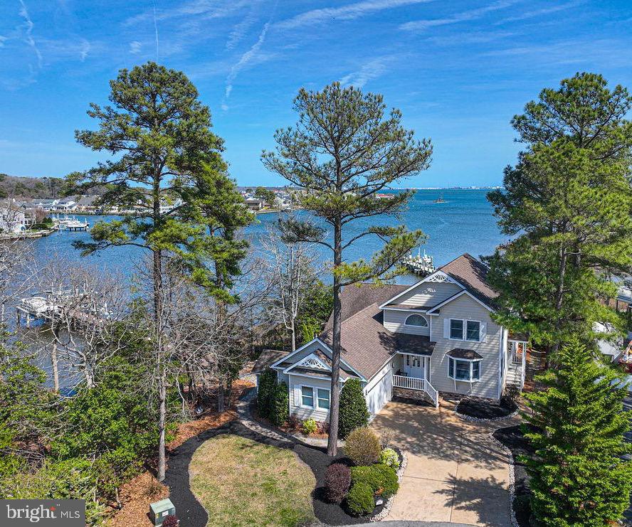 Spectacular panoramic water views are the centerpiece of this exceptional waterfront property located on a quiet cul-de-sac in one of Ocean Pines’ premier neighborhoods. With approximately 250 feet of shoreline, this rare setting offers breathtaking views in two directions — enjoy stunning sunrises in the morning and watch the evening lights of the Ocean City skyline glisten across the bay.

Offered for the first time by the original owners and used primarily as a vacation home, this spacious residence offers 4 bedrooms plus a loft, with every bedroom connected directly to a bathroom for added comfort and convenience. Two bedrooms are located on the first floor, including a recently remodeled first-floor bathroom, providing flexible living options.

Designed to embrace the waterfront lifestyle, the home features multiple outdoor living spaces including a large deck, screened porch, roof deck, and a private hot tub area — all positioned to capture the incredible water views.

Boaters will appreciate the private dock with two boat lifts and two jet ski lifts, making it easy to enjoy days on the water. Interior features include vaulted ceilings, Andersen windows, generous closet space, and a large laundry room. The home is equipped with two HVAC systems, with one AC unit replaced in May 2019, and a 75-gallon natural gas water heater installed in April 2024.

This property offers a rare combination of privacy, breathtaking views, and waterfront living, making it a truly special opportunity in Ocean Pines.