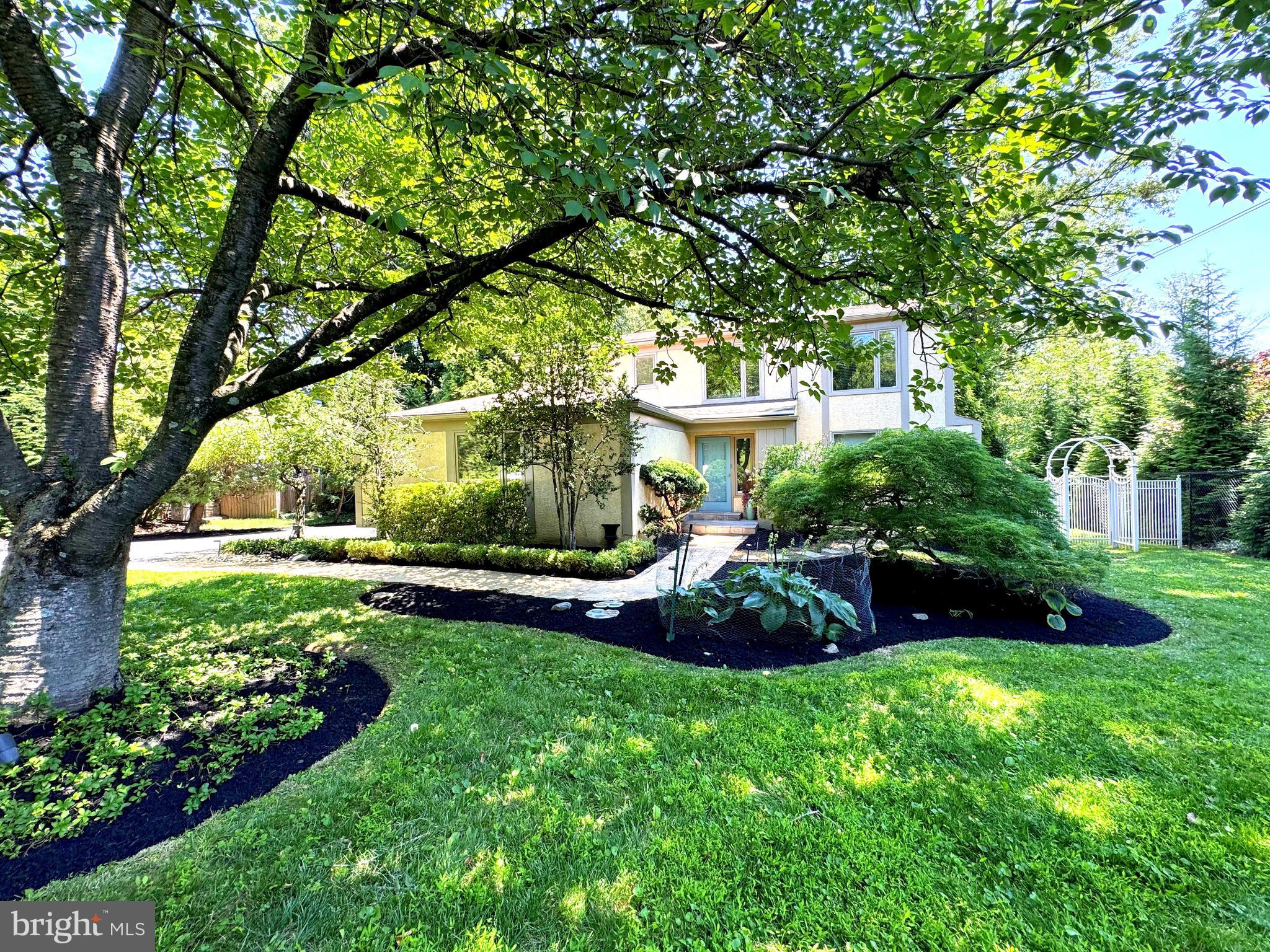 Set well back from the road on a lush, flat 0.5-acre lot, this striking 4-bedroom contemporary residence blends custom design, quality craftsmanship & elegant modern living in one of Penn Valley’s most desirable locations.
A circular driveway welcomes you to a two-car garage & a winding brick paver walkway that leads to the front door. Inside, the gracious marble-floored center hall sets the tone with a large coat closet & an open, balconied staircase leading to the second floor.
The sun-filled living room features hardwood floors, a large picture window & distinctive architectural see-through walls creating visual continuity & modern flair. The adjacent family room is a warm, sophisticated gathering space with hardwood floors, a honed marble fireplace & custom, handcrafted walnut cabinetry, including a matching wet bar. French doors with sidelights open to a terracotta-tiled, awning-covered patio that overlooks the expansive, private rear yard, ideal for relaxing or entertaining.
The spacious formal dining room offers marble floors & three large windows with front & side views. The bright kitchen features a picture window overlooking the gardens, white cabinetry, granite countertops & top-tier appliances including a Wolf gas range, Best exhaust hood, GE Monogram built-in refrigerator, dishwasher & a wine rack. The adjoining breakfast area offers space for a large table, additional views of the backyard & offers a connecting full laundry room with patio access.  From the hallway, there is a guest powder room with mirrored wall & custom wall sconces, completing the main level.
Upstairs, a vaulted ceiling & open balconied hallway add volume & light. The primary suite features French doors with a Juliet balcony, a wall of custom Italian Poliform built-in storage cabinets & a private dressing room with built-in vanity, walk-in closet & access to a luxurious Carrara marble bath with oversized shower, double windows, large vanity & custom cabinetry.
Three additional bedrooms are spacious & bright, with ample closet space. A beautifully finished hall bath includes custom tile, built-in cabinetry, pedestal sink, large tub/shower & stylish finishes.
The finished lower level boasts flexible space for recreation, fitness, work, or guests. It includes a game room, large, shelved closet, under-stair storage, a mirrored exercise area, an office with cedar closet & a full bathroom. There is also a large unfinished area perfect for storage & utilities.
This thoughtfully designed home offers privacy, light & architectural interest just minutes from top-rated Lower Merion schools, Center City &  all the best of the Main Line!