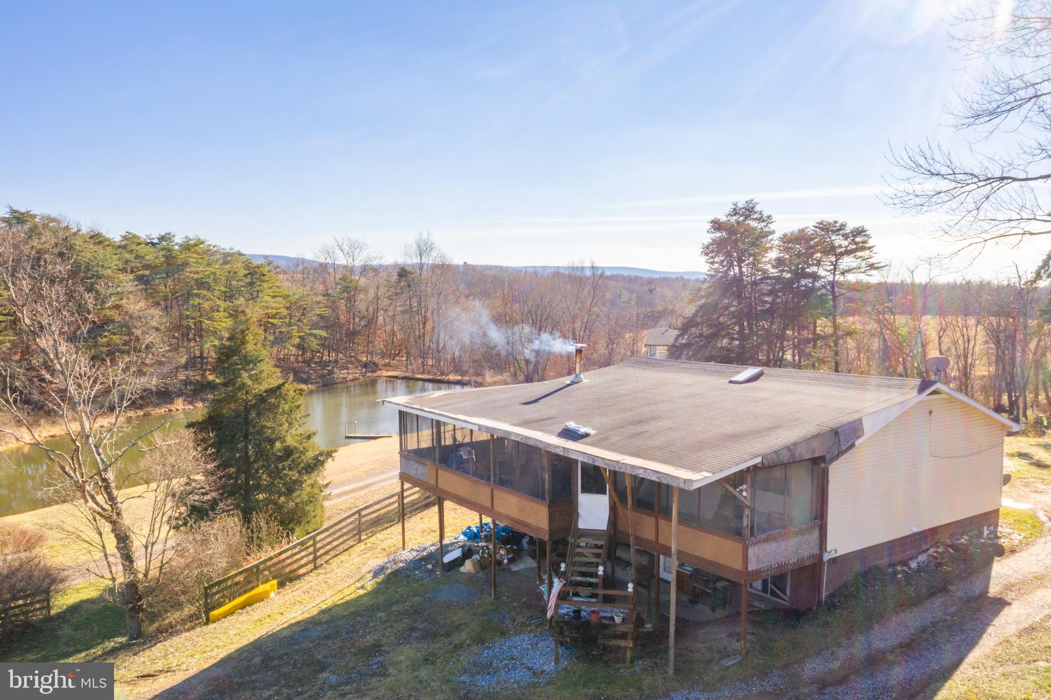 AS-IS 2 bedroom 1.5 bath home located just outside of Berkeley Springs, WV. This home features porches that wrap 3/4 around making it the perfect property to take in the beautiful scenery that Morgan County, West Virginia has to offer. The back yard shows potential for gardening, recreation, and a bit of quiet during the day.  The basement including the half bath need work. A great selling point of this home is the renovated kitchen that is at the center of this home. Don't wait to take a look.