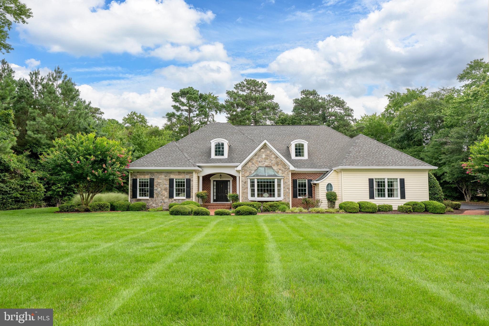 Impeccably maintained and move-in ready, this custom home is situated on 1.36 beautifully landscaped acres within the sought-after, restricted community of Rivers End. Surrounded by mature trees, the property showcases exceptional curb appeal with a brick walkway, stone accents, landscape lighting, and an in-ground irrigation system designed to keep the grounds looking their best year-round.

Offering 3 bedrooms, 2 full baths, and 3 half baths, this thoughtfully designed home features spacious living areas ideal for both everyday living and entertaining. All three bedrooms are conveniently located on the first floor, including a spacious primary suite featuring a large walk-in closet and adjacent laundry area for added convenience. The main level also includes a formal dining room, a generously sized kitchen complete with abundant cabinetry, center island, breakfast bar with wine refrigerator, and dining area, as well as a welcoming living room highlighted by a fireplace. Located just beyond the living room, the sunroom is filled with natural light and provides the perfect space for relaxing, reading, or enjoying views of the beautifully landscaped backyard.

The second floor significantly expands the living space with a large recreation room, kitchenette with sink, refrigerator, dining area, and extensive cabinetry for storage. A private office with closet offers the flexibility of a potential fourth bedroom, while the additional half bath makes the upper level ideal for guests, hobbies, a home office, or multi-generational living. A separate walk-in attic provides exceptional storage space rarely found in today's homes.

Additional highlights include a three-car attached garage, abundant storage throughout, and a rear deck overlooking the meticulously maintained backyard and wooded backdrop. Recent improvements include a newly encapsulated crawl space, providing enhanced moisture control and long-term protection. Combining quality craftsmanship, flexible living spaces, and exceptional outdoor amenities, this property offers a rare opportunity to enjoy privacy, space, and comfort in one of the area's most desirable communities while remaining conveniently close to shopping, dining, healthcare, and Delaware's beaches.