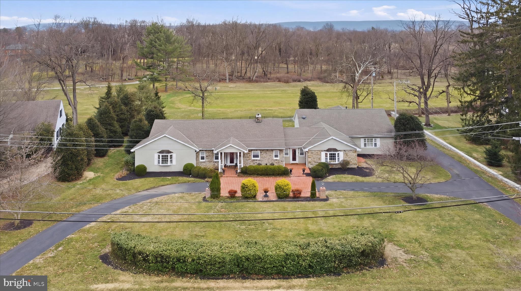 Incredible opportunity to own this gorgeous, state-of-the-art home featuring only the highest appointments throughout. This fabulous fieldstone rancher offers breathtaking views of Fountain Head Golf Course from nearly every room, blending timeless craftsmanship with modern luxury.
The impressive gourmet kitchen showcases upgraded appliances, custom handmade cabinetry, exotic granite countertops, and opens to a spacious dining area ideal for both everyday living and effortless entertaining. Generous living spaces are filled with natural light and enhanced by refined architectural details, gleaming hardwoods, and quality finishes throughout.

The stunning primary suite features exquisite appointments and a serene, private atmosphere. The spa-inspired primary bath is second to none, offering high-end finishes and a true retreat experience. Outdoor living is just as exceptional, with a large brick patio overlooking the 15th fairway perfect for relaxing or entertaining along with a screened-in porch that allows you to enjoy the views in comfort throughout the seasons. No detail is overlooked in the home which truly is second to none!
Additional highlights include a two-car side-loading garage equipped with a Tesla charger, thoughtful upgrades throughout, and a layout designed for both elegance and ease of living. This special offering won’t last. Make your appointment today!