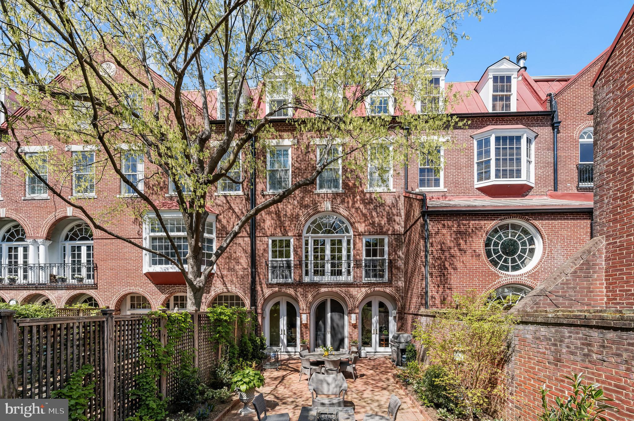 This very special residence, at one time home to Jacqueline Kennedy Onassis' mother and sister, was among six homes built in 1990 and designed  by noted architect Robert Bell in what was once the city's Seventh Precinct Police Station.   The home, approx 3800sf, is four full floors of living space with small elevator accessing all levels.  The interior garage is designed for one car with a very basic lift to elevate a small second car (lift is functional but  conveys as is).  The entertaining spaces are spectacular - the dining room with FP seats many and opens to lovely deep garden;  can also be a hybrid dining/ family room arrangement.  The living room - 21'x23' , with large Palladian windows opening to a Juliet balcony and overlooking a beautiful professionally designed deep garden, has wonderfully high 10'7"ceilings , a gas fireplace, wet bar and is huge - great for entertaining.  The primary suite  is luxuriously spacious with a gas fireplace and a connecting large bath to a second bedroom currently arranged as a library/office ; the top floor has 2 very large bedrooms and 2 baths.  The gourmet kitchen was completely redone in early 2015, all bathrooms are WaterWorks.  Steps to Wisconsin Ave, this wonderfully located and stylish house provides comfortable and updated conveniences in the heart of beautiful historic Georgetown.     House is in excellent condition and has great storage throughout.