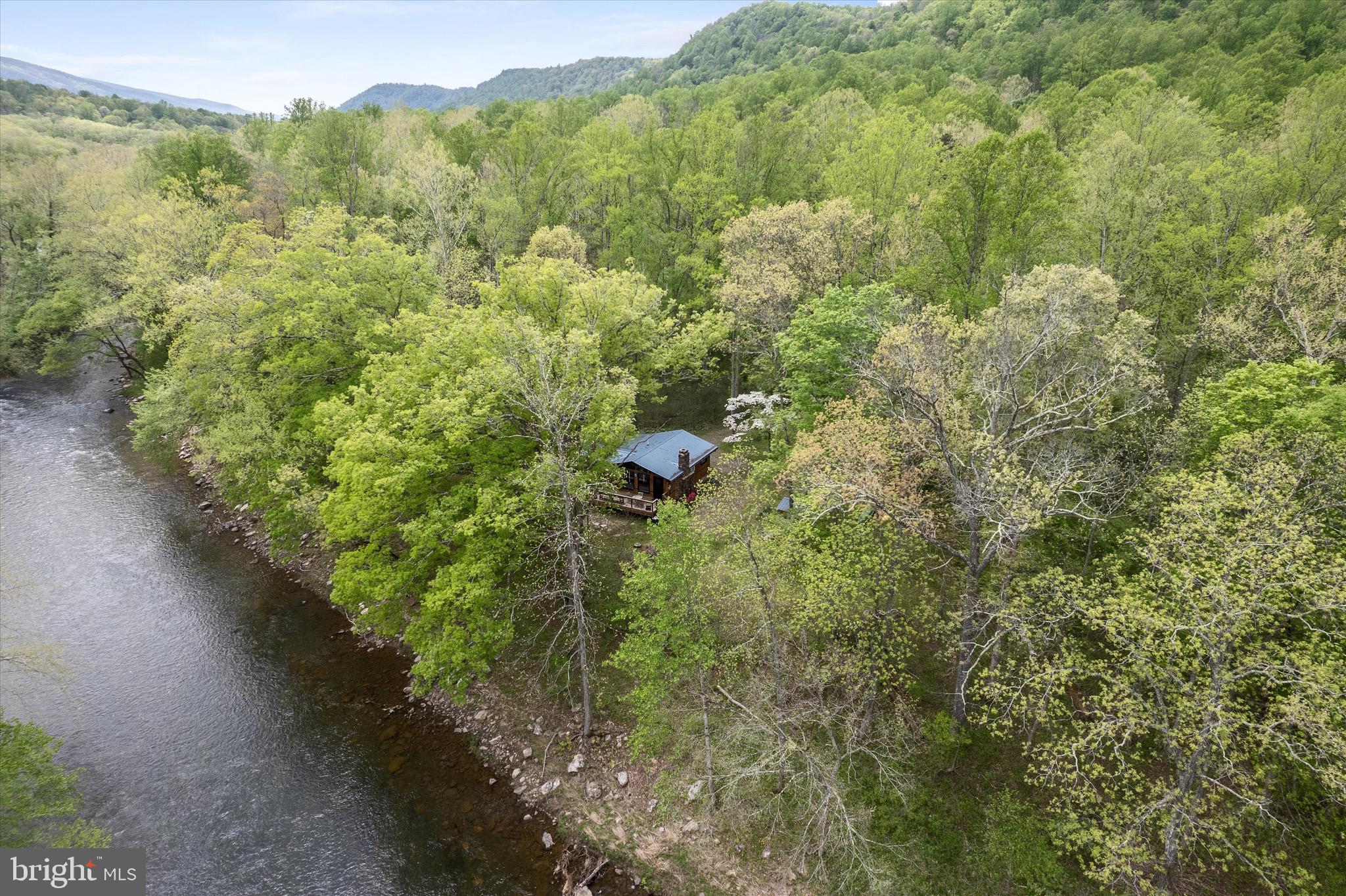 Outdoor Living at 8 Dew Drop Ln, Great Cacapon, WV

Experience the ultimate riverside retreat at 8 Dew Drop Lane, nestled along 300 feet of private Cacapon River frontage. This 5 acre property offers unparalleled outdoor living in a secluded, nature-filled setting.​

So many updates! Bathroom remodeled, laundry added and enjoy views year round in this adorable sunroom. Fiber internet installed last year, making remote working a breeze.

Step out your door to launch your canoe, kayak, or tube directly into the river. Enjoy fishing, swimming, or simply relaxing by the water's edge. The expansive riverfront provides a perfect backdrop for outdoor activities and tranquil moments.​

The cabin features a generous deck that runs along the front, ideal for morning coffees or evening gatherings. Gather around the fire pit for cozy nights under the stars, or unwind on the swing nearby, listening to the sounds of the river and wildlife. This serene setting is perfect for relaxation and creating lasting memories.​

A separate, covered, porch provides additional living space, ideal for sleeping, playing, or storing outdoor gear. An outdoor shower adds a refreshing touch after a day of river activities.​

Located within a recreational community, the cabin is surrounded by wooded lots, ensuring privacy and immersion in nature. 

Whether seeking adventure or tranquility, 8 Dew Drop Lane offers a perfect blend of outdoor living and natural beauty. Don't miss the opportunity to experience this exceptional riverside retreat.​