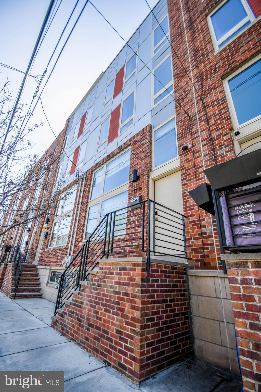 Welcome to 1310 S. 20th Street — a luxury townhome, built in 2018, is a stunning combination of comfort and style, with a private roof top deck,  approximately 2 years left on the tax abatement, and with rare private gated garage parking with interior access—a true luxury in this sought-after neighborhood at Wharton Place in the heart of South Philly!

Step inside to find a bright and airy living/den space with 14 foot ceilings and tons of natural light. Up a few steps you enter the inviting kitchen and dining area. The kitchen boasts stainless steel appliances, waterfall island countertop, dishwasher, double door refrigerator, quartz countertops, and more than ample cabinets perfect for every day meal prep and entertaining. The thoughtfully designed layout flows seamlessly into the dining space that overlooks the lower level living room through a sleek glass wall that reeps all the benefits from the natural light coming through the large front windows.  Next to kitchen is a guest half bathroom. 

Upstairs, you’ll find 2 spacious bedrooms with great extra large windows for tons of natural light and custom closet systems. Nestled between the bedrooms is the first of 2 full bathrooms. This floor also houses the laundry closet with almost new washer and dryer applicances in place.  The third floor hosts the primary suite with custom walk in closet and a spa like bathroom with a dual sink vanity. The suite can be closed off for added privacy. This floor also has a guest half bath just before heading up to the roof top deck. Yep! Your own private deck with amazing views of the beautiful City skysline. This outdoor space provides an ideal setting for morning coffee, weekend barbecues, or simply unwinding after a long day. 

But wait there is more... the lower level is a full finished basement with interior access to the garage and additional living and closet space with recessed lighting.

Located just minutes from all of the City's finest parks, shopping, hospitals and universities, and public transportation, this home places you in the center of it all while still offering a quiet residential feel.

Don’t miss your chance to own a home that checks all the boxes—schedule your showing today and experience everything 1310 S. 20th Street has to offer!