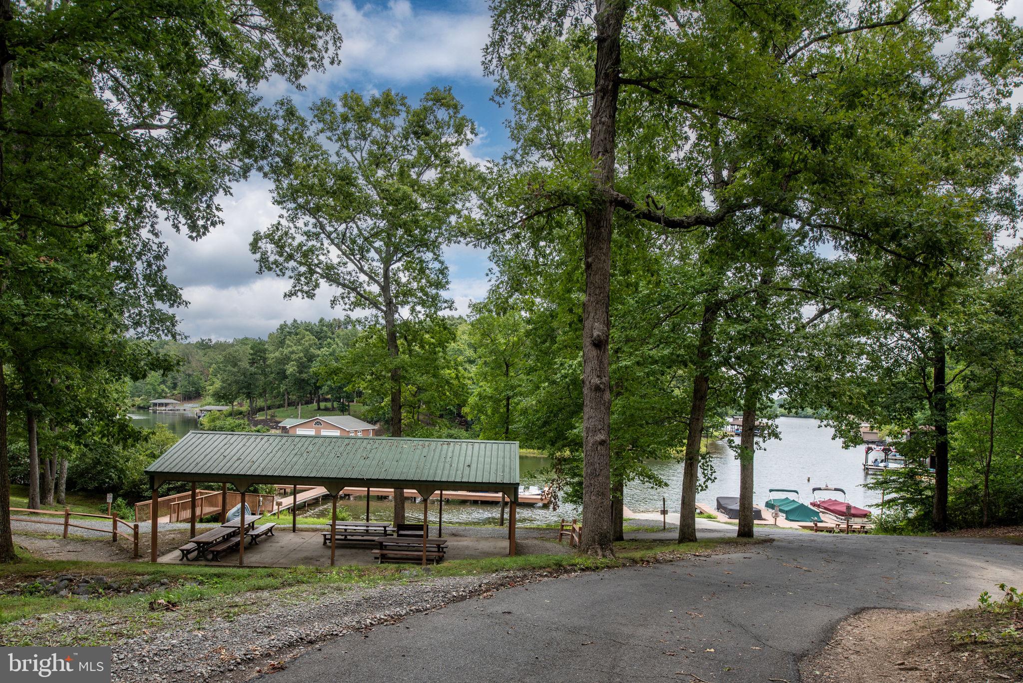 1.85 Acre Lake Access building lot located on Lake Anna’s public side awaits you. The Lot is partially cleared, Driveway in and a drilled Well ready for your dream home.  Located in Pine Harbour, a gated golf cart-friendly community. The common area offers an idyllic gathering place with a picnic area, gazebo, and boat launching. For boating enthusiasts, Boat slips can be leased or take advantage of the day-use slips for spontaneous adventures.  Just beyond the community, conveniences abound. Restaurants, grocery store, breweries, a golf course, and a veterinary hospital are only a short drive away, ensuring you never need to go far for essentials or entertainment. This home site perfectly marries seclusion and community, offering an ideal spot for a permanent hideaway or a chic vacation home. Time to claim your slice of lakeside living and let the good times roll! Community allows short term rentals.