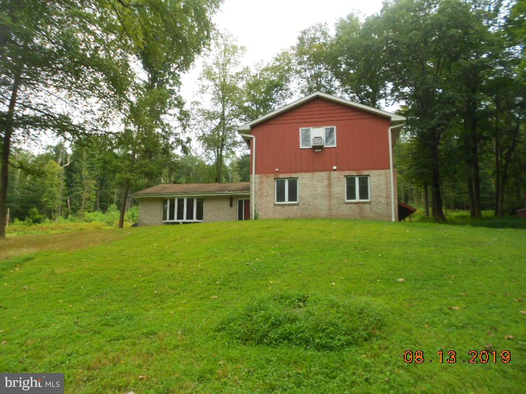 Corporate owned property being sold as-is condition with no seller disclosure. Purchaser is responsible for the 2% transfer tax, all inspections, permits and all cost associated with them. Built prior to 1978 so lead based paint is probable. This property may qualify for Seller Financing. If you are looking for country, private and a serene setting then this home might be what you are looking for. This can be a grand home with some work. Offers so much living space, hardwood floors and a fireplace in the family room and privacy, privacy and privacy. Large covered patio in the back to watch the wildlife.