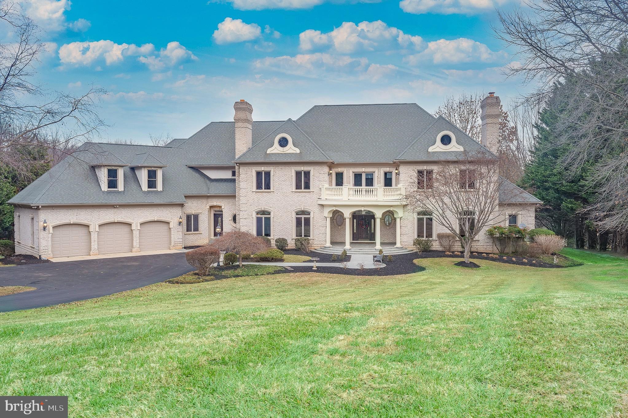This custom-built brick estate offers exceptional craftsmanship and superior finishes through-out more than 12,000 square feet of living space. Privately situated at the end of a cul-de-sac on a picturesque 3.53-acre lot in the coveted Ridgewood community, the property features an in-ground pool, plentiful patios and scenic views of a private pond. Inside, ceilings ranging from ten to twenty feet showcase an array of architectural treatments, including tray, vaulted, and barrel designs. The home is richly appointed with five cast stone fireplaces, dual staircases, custom mouldings, window treatments, pillars, and graceful arches. The main level is highlighted by a grand great room, a sun-filled solarium, and a stately library. The primary suite, also located on the main level, features Alabaster light fixtures, dual vanities, a jetted tub, a roll-in ceramic shower, and four walk-in California closets. The fully equipped and expansive kitchen is outfitted with a granite center island, quartz perimeter countertops, Cherry cabinetry, dual sinks, and ceramic flooring, opening to a bright breakfast room with access to the covered porch, stamped concrete patios and wall fountain. The upper level offers a wrap-around interior promenade connecting five bedrooms, three full baths, an Azek patio, a second laundry room and a cedar-lined storage room. The walk-out lower level includes a media room, game room, family room, half bath, and substantial unfinished space well-suited for an apartment, in-law or au pair suite.  Hallway walk-in closets are roughed-in and vertically aligned to accommodate a future three-level elevator. Parking is plentiful with a three-car garage and an additional heated, oversized one-car garage with direct access to the basement. The home is serviced by a private well and septic system, five separate oil-fueled HVAC systems and 600-amp electrical service. Conveniently located near highly rated schools, the property offers easy access to Washington, DC, Baltimore, Annapolis, and Frederick, as well as close proximity to BWI, NSA, NASA, MARC rail, and major transportation routes.