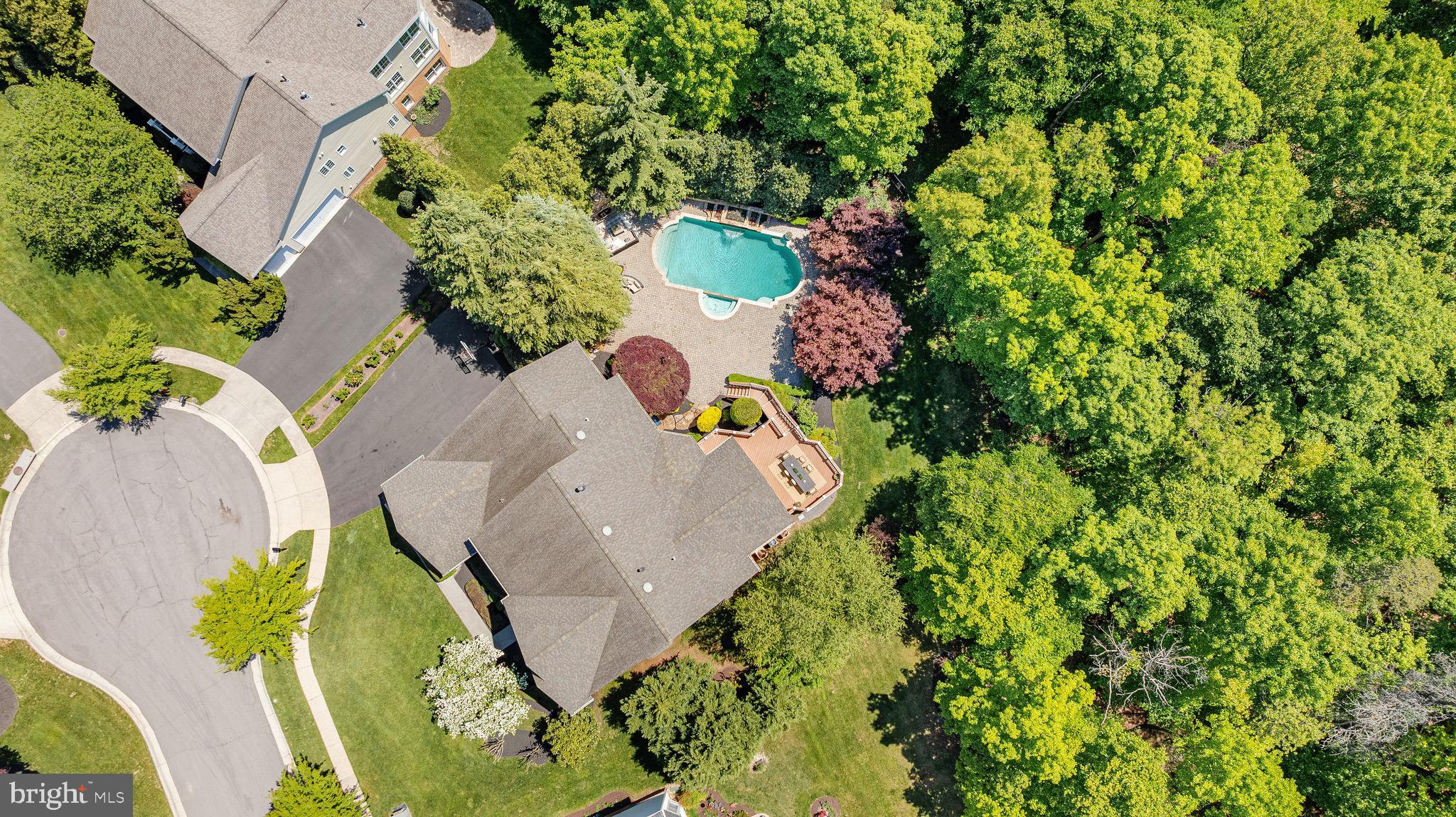 On the banks of scenic Goose Creek, this impressive estate of significant influence awaits in a highly exclusive cul de sac in the community of Lansdowne on the Potomac. A stately brick colonial home combined with a private pool on a premium lot all backing to mature trees for exceptional seclusion is simply unmatched for this community. Lush landscaping framed with stately colonial architecture as the home greets you with a dramatic double height foyer with sweeping stairs and art quality lighting. The entrance flows seamlessly across the formal dining room with butler’s pantry, private reading library, home office, sunroom and enlarged gathering room. Guests will be awestruck by sunlight beaming in through an abundance of views from the windows as this path will lead to the open concept chef’s kitchen. In the timeless chef inspired kitchen, create best-loved recipes with the help of professional grade Viking and Sub-Zero appliances. Guests and family alike will adore savory holiday meals in the dining room, and joyful brunches in the luxurious sunlit breakfast room. From the kitchen, a meticulously framed ceiling will guide and delight as you explore the 7,600+ sq. ft. home. Intimate conversations and splendid gatherings alike are yours to host within several irresistible living spaces, while the main level study provide privacy for remote work, you can also relax in the reading room during the evenings with a book. Beautiful detailed hardwood floors will escort you to the home’s second level where the grand entrance offers views of dewy mornings and the meticulous landscaping. In the evenings, spacious bedrooms and spa-like bathrooms allow family and guests to unwind. In the primary suite, choose to relax in the dual shower or with an evening of bubbles in the regal soaking tub. Afterwards, your sitting-room with a miniature tea/wine bar beckons you to continue plans of blissfully hiding away. A elegant primary retreat with a spacious custom closet featuring tailored shelving and an exclusive second story balcony with tranquil poolside views offer an easy escape from a busy day. There’s no shortage of entertainment and pampering as the home offers movie nights in the theater, a lower level parlor, wine-tasting bar, home gym, crafts/hobby area, sports viewing room, pool/ping-pong table room and featuring a floor to ceiling cedar-lined storage room to store designer luxury goods. A lower level bedroom can be ideal for extended guests. As you approach the exit to the garage, an expanded mudroom with ample shelving for week long activities leads to a main level deluxe laundry room, complete with a concierge style high end steam closet for dry cleaner quality care for delicate clothing. Outside, a 3 car side load garage ensures effortless daily access and abundant space for vehicles and storage, combining convenience with refined functionality. Treat your guests to sunny afternoons by the pool and moonlit evenings near your custom outdoor wood burning fireplace. The residence features a sophisticated, multi-tiered surround sound system integrated throughout both the interior living spaces and the exterior pool area, delivering an exceptional audio experience designed for elevated entertaining. As a member of the community, you’ll enjoy access to the exclusive Potomac Club, which offers swimming, tennis, billiards, gym membership, and event space. In addition, membership is available at the nearby Lansdowne Resort, which offers golf, spa services, and fine dining. Refresh your mood and connect to nature via the area’s numerous hiking trails, or choose to go boating and fishing on the Potomac River or Goose Creek. Nearby historic downtown Leesburg offers posh farm-to-fork restaurants, boutique shopping, and town festivals. Further afield, Washington D.C. will entertain with urban flair, and nearby Dulles International Airport awaits to transport you anywhere in the world!